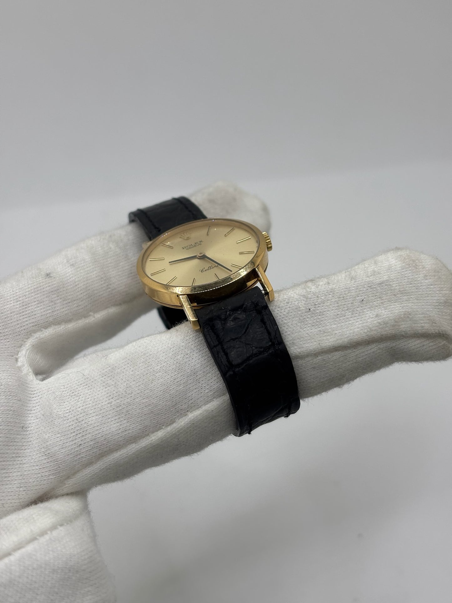 Montre Rolex Cellini référence 4109 vintage en or jaune de 1976, équipée d’un mouvement à remontage manuel calibre 1601. Boîtier de 26 mm en or jaune avec lunette assortie, cadran doré à index bâtons et verre saphir. Bracelet en cuir noir avec boucle ardillon en acier. Montre femme élégante d’occasion en bon état présentant des traces d’usure visibles (rayures et petites marques). Révisée en interne le 30 juin 2026, livrée avec coffret d’origine sans papiers.