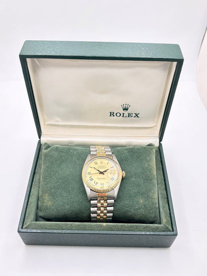Montre Rolex Datejust 16013 vintage en très bon état, datant de 1979, équipée d’un mouvement automatique calibre 3035 avec 42 heures de réserve de marche. Son boîtier de 36 mm en or et acier possède une lunette en or jaune et un verre Plexiglas. Son cadran or à chiffres romains est accompagné d’un bracelet or et acier. Cette Rolex Datejust dispose également d’une fonction date et d’une étanchéité à 10 ATM.