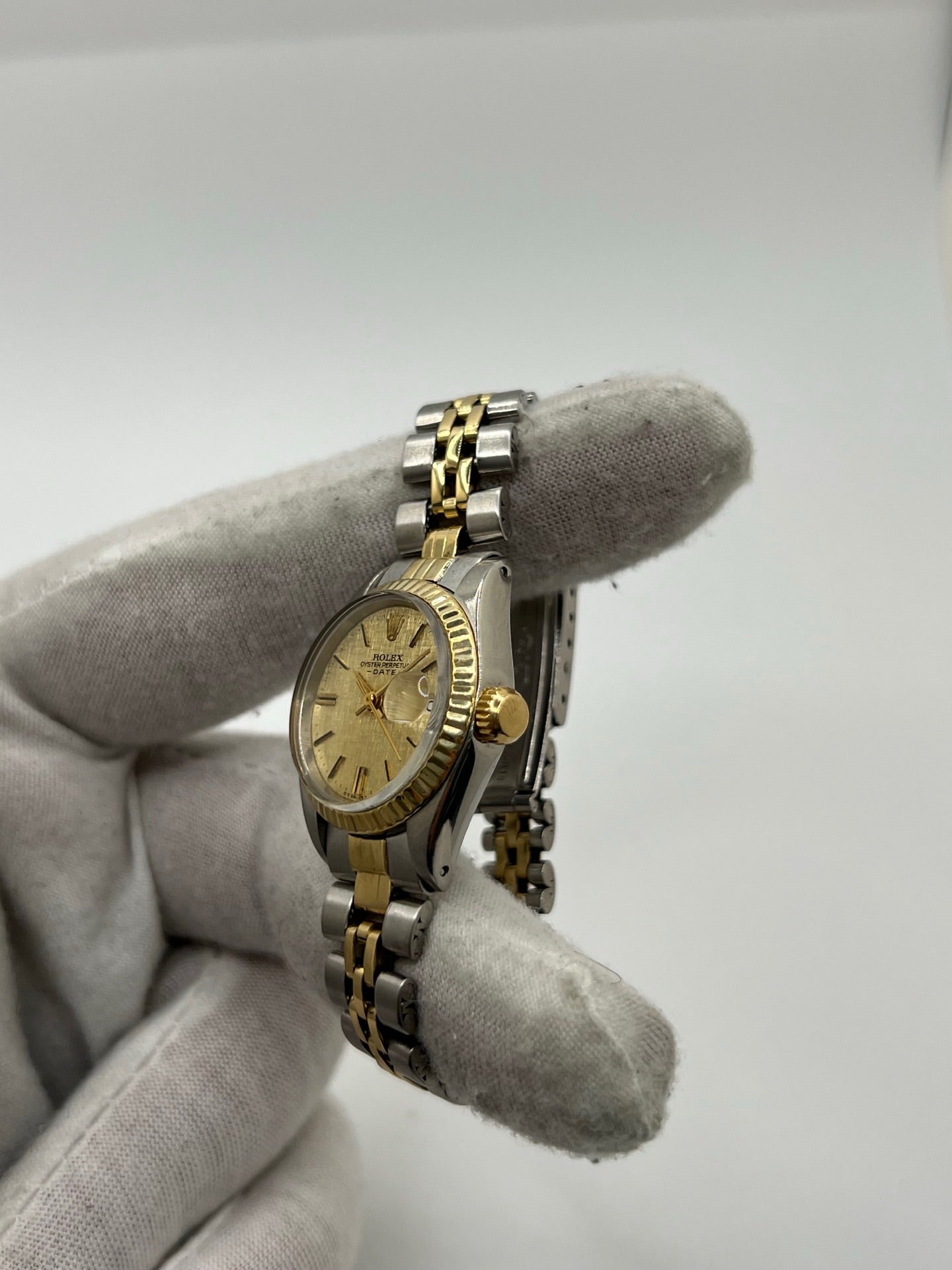 Montre Lady-Datejust référence 69173 en acier et or jaune avec cadran champagne et lunette cannelée en or jaune. Modèle féminin emblématique doté d’un mouvement automatique calibre 2135 et d’un boîtier de 26 mm avec verre saphir. Bracelet bicolore acier et or avec boucle pliante. Montre élégante et intemporelle, appréciée pour son design raffiné et sa fonction date, idéale pour les amateurs de montres classiques et d’horlogerie suisse.
