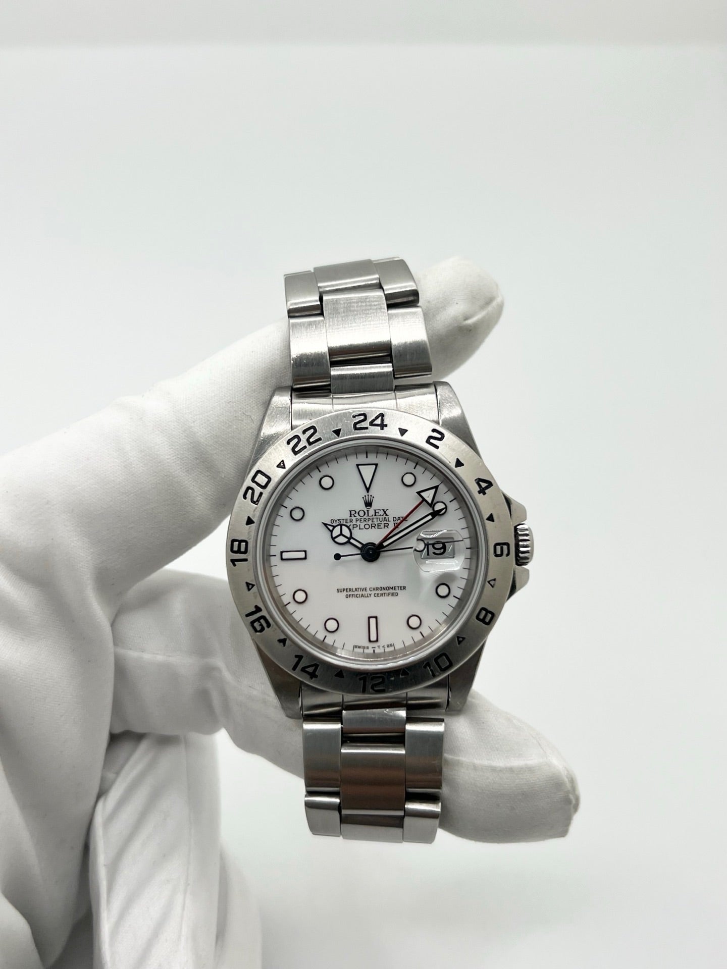 Montre Rolex Explorer II 16570 pour homme ou unisexe en acier, équipée d’un mouvement automatique calibre 3185 avec réserve de marche de 50 heures. Ce modèle emblématique de 1989 présente un boîtier de 40 mm, une lunette en acier, un cadran blanc sans chiffres, un verre saphir et un bracelet en acier avec boucle pliante. Fonction date et GMT. Montre de luxe d’occasion en bon état, révisée en interne, avec coffret d’origine, idéale pour les amateurs de Rolex Explorer II vintage.