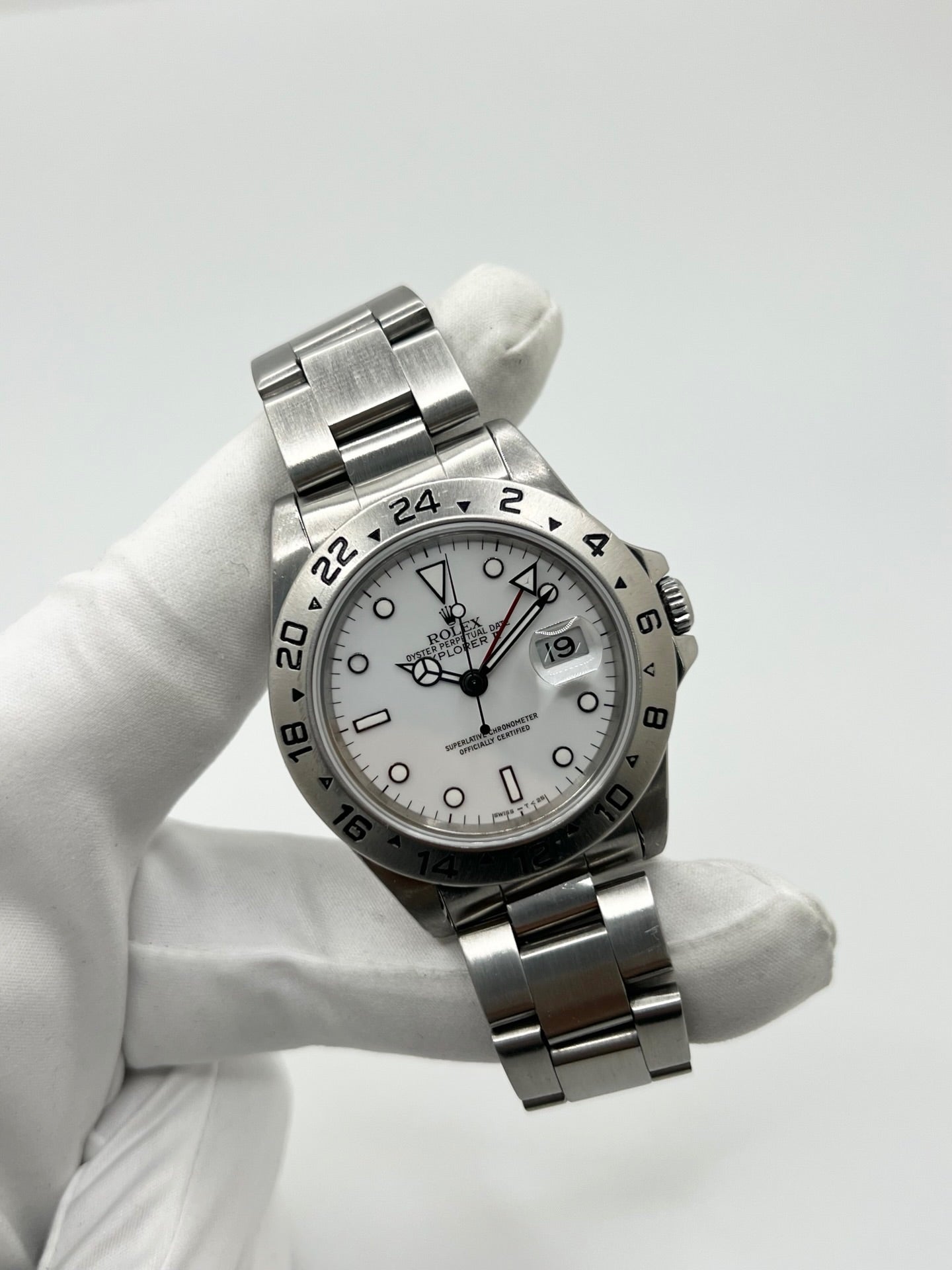 Montre Rolex Explorer II 16570 pour homme ou unisexe en acier, équipée d’un mouvement automatique calibre 3185 avec réserve de marche de 50 heures. Ce modèle emblématique de 1989 présente un boîtier de 40 mm, une lunette en acier, un cadran blanc sans chiffres, un verre saphir et un bracelet en acier avec boucle pliante. Fonction date et GMT. Montre de luxe d’occasion en bon état, révisée en interne, avec coffret d’origine, idéale pour les amateurs de Rolex Explorer II vintage.