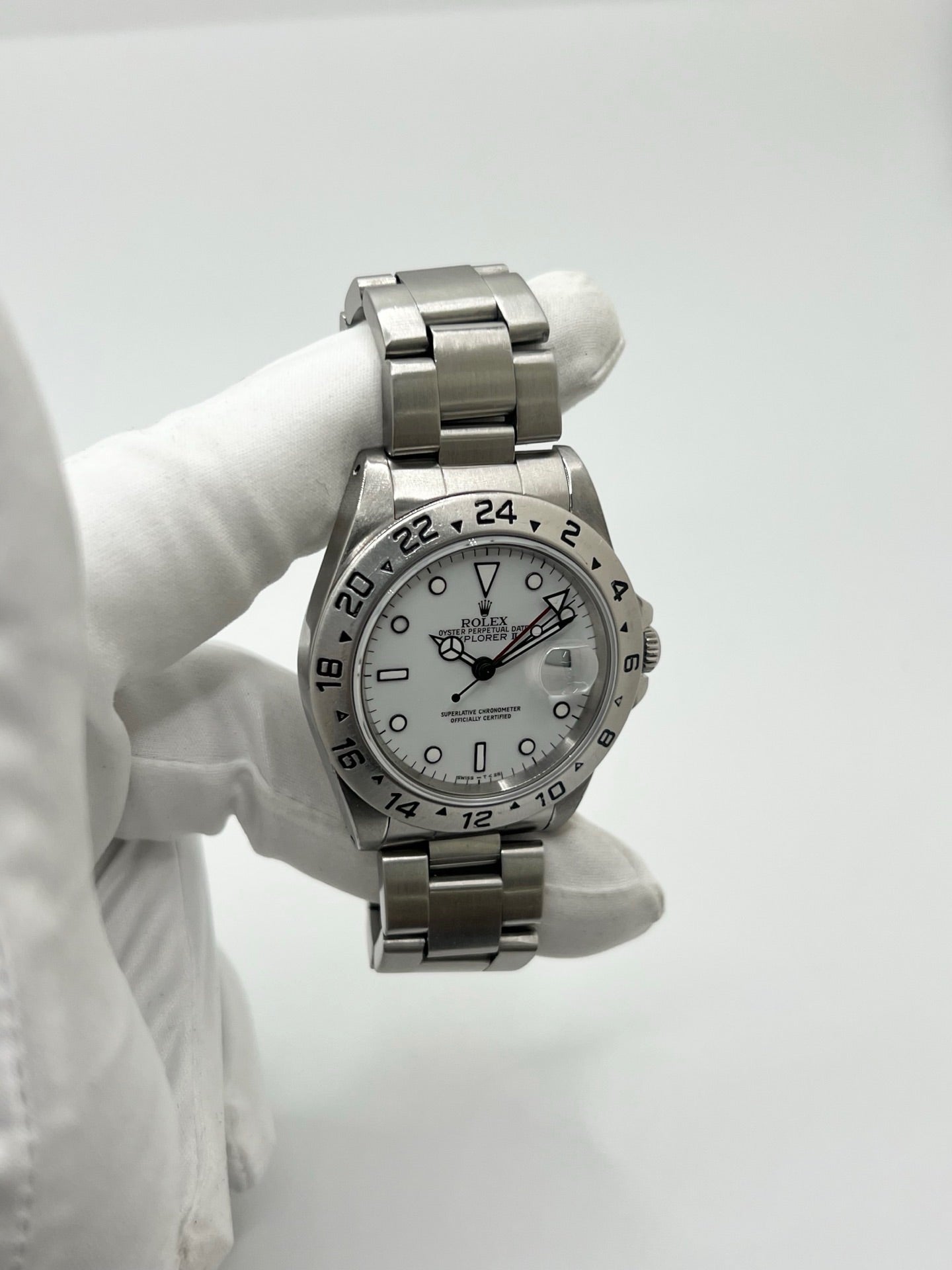 Montre Rolex Explorer II 16570 pour homme ou unisexe en acier, équipée d’un mouvement automatique calibre 3185 avec réserve de marche de 50 heures. Ce modèle emblématique de 1989 présente un boîtier de 40 mm, une lunette en acier, un cadran blanc sans chiffres, un verre saphir et un bracelet en acier avec boucle pliante. Fonction date et GMT. Montre de luxe d’occasion en bon état, révisée en interne, avec coffret d’origine, idéale pour les amateurs de Rolex Explorer II vintage.