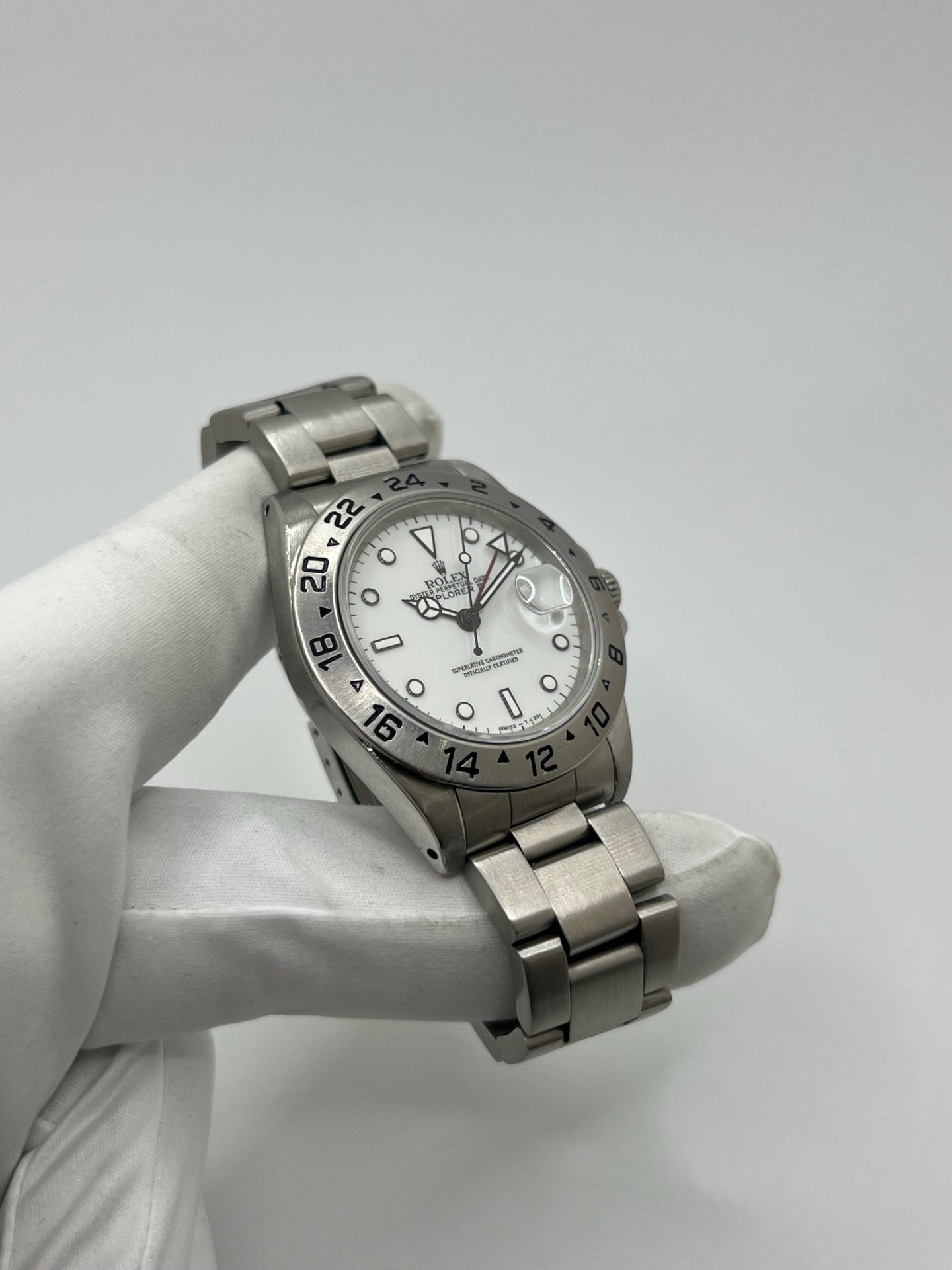 Montre Rolex Explorer II 16570 pour homme ou unisexe en acier, équipée d’un mouvement automatique calibre 3185 avec réserve de marche de 50 heures. Ce modèle emblématique de 1989 présente un boîtier de 40 mm, une lunette en acier, un cadran blanc sans chiffres, un verre saphir et un bracelet en acier avec boucle pliante. Fonction date et GMT. Montre de luxe d’occasion en bon état, révisée en interne, avec coffret d’origine, idéale pour les amateurs de Rolex Explorer II vintage.