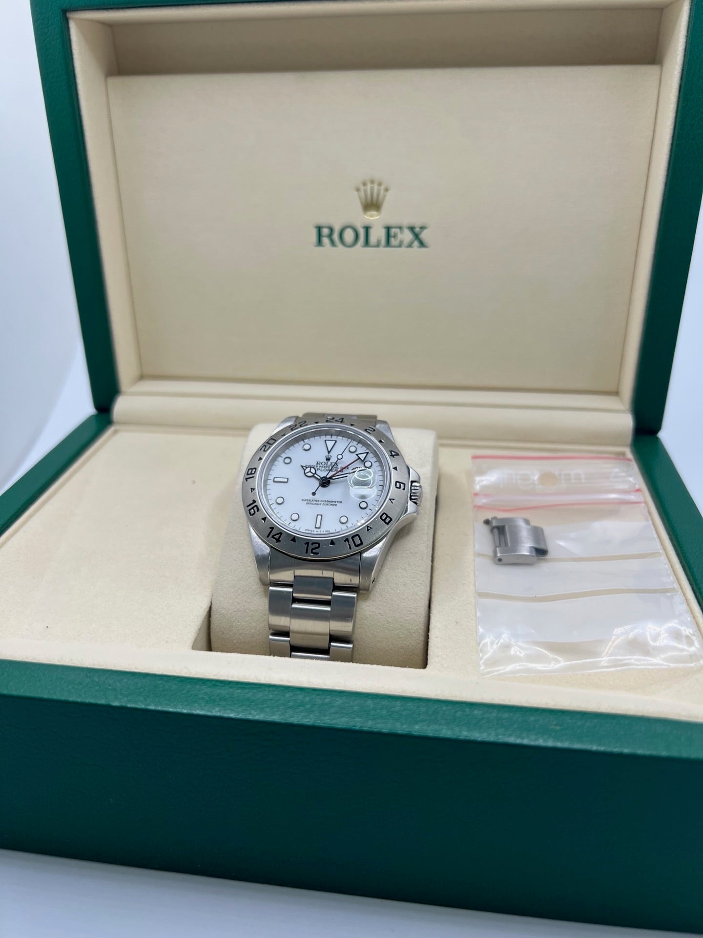 Montre Rolex Explorer II 16570 pour homme ou unisexe en acier, équipée d’un mouvement automatique calibre 3185 avec réserve de marche de 50 heures. Ce modèle emblématique de 1989 présente un boîtier de 40 mm, une lunette en acier, un cadran blanc sans chiffres, un verre saphir et un bracelet en acier avec boucle pliante. Fonction date et GMT. Montre de luxe d’occasion en bon état, révisée en interne, avec coffret d’origine, idéale pour les amateurs de Rolex Explorer II vintage.