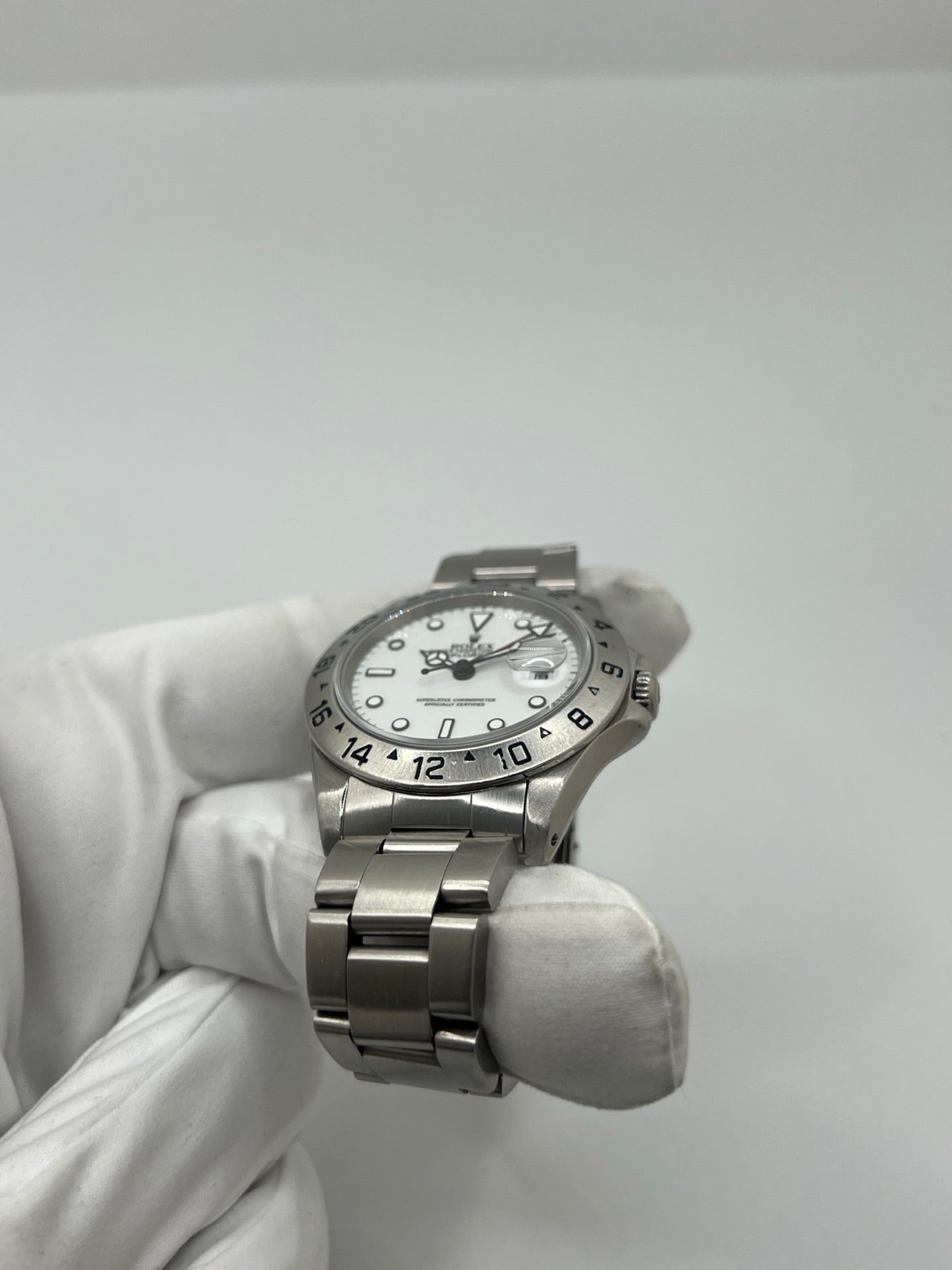 Montre Rolex Explorer II 16570 pour homme ou unisexe en acier, équipée d’un mouvement automatique calibre 3185 avec réserve de marche de 50 heures. Ce modèle emblématique de 1989 présente un boîtier de 40 mm, une lunette en acier, un cadran blanc sans chiffres, un verre saphir et un bracelet en acier avec boucle pliante. Fonction date et GMT. Montre de luxe d’occasion en bon état, révisée en interne, avec coffret d’origine, idéale pour les amateurs de Rolex Explorer II vintage.