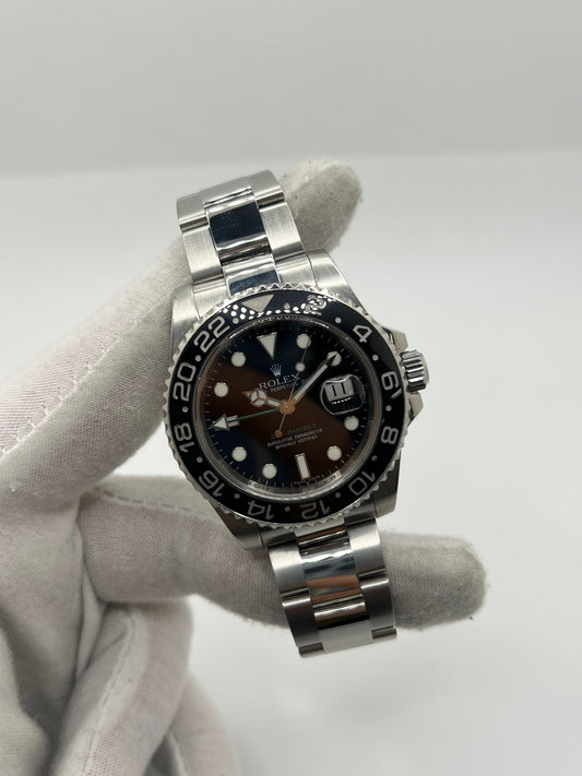 Montre GMT-Master II référence 116710LN en acier avec cadran noir et lunette en céramique noire. Modèle emblématique doté d’un mouvement automatique calibre 3186 avec fonction GMT permettant l’affichage d’un second fuseau horaire. Boîtier de 40 mm avec verre saphir et bracelet acier avec boucle pliante. Montre sportive et élégante, appréciée pour sa robustesse, sa lisibilité et son design iconique dans l’univers de l’horlogerie suisse.