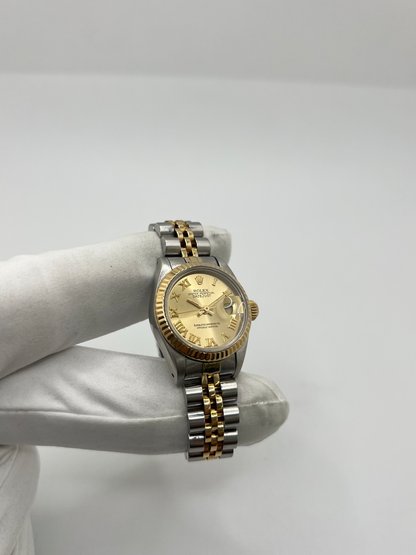 Montre Rolex Lady-Datejust 69173 de 1983 en acier et or jaune avec cadran champagne à chiffres romains, lunette cannelée et bracelet Jubilé. Cette Rolex Lady-Datejust 26 mm automatique est équipée du calibre Rolex 2135 avec affichage de la date et verre saphir. Élégante et intemporelle, cette Rolex femme vintage associe raffinement et confort grâce à son bracelet iconique acier et or. Montre livrée avec boîte d’origine, certificat d’authenticité et garantie 1 an.