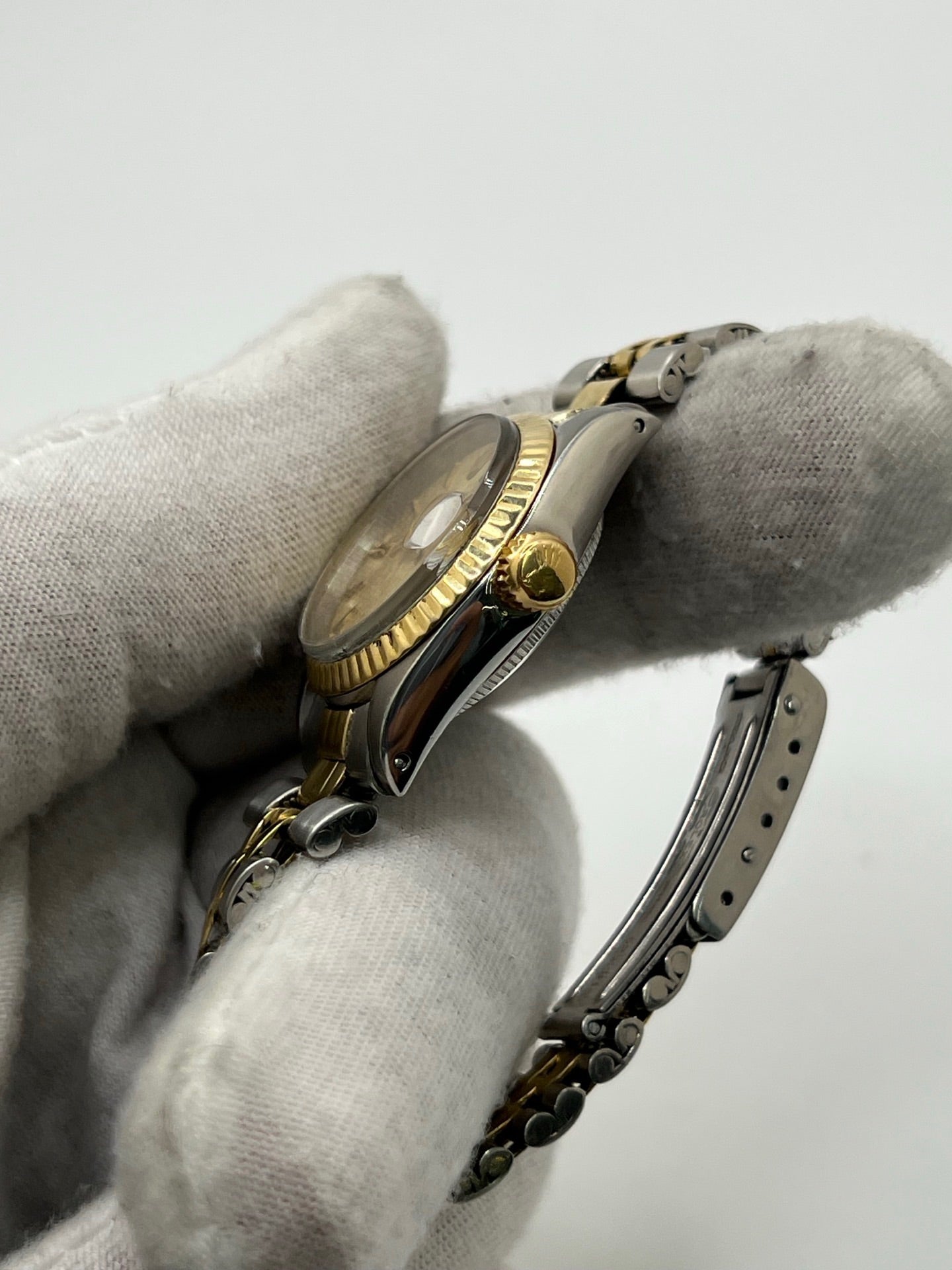Montre Lady-Datejust référence 69173 en acier et or jaune avec cadran champagne et lunette cannelée en or jaune. Modèle féminin emblématique doté d’un mouvement automatique calibre 2135 et d’un boîtier de 26 mm avec verre saphir. Bracelet bicolore acier et or avec boucle pliante. Montre élégante et intemporelle, appréciée pour son design raffiné et sa fonction date, idéale pour les amateurs de montres classiques et d’horlogerie suisse.