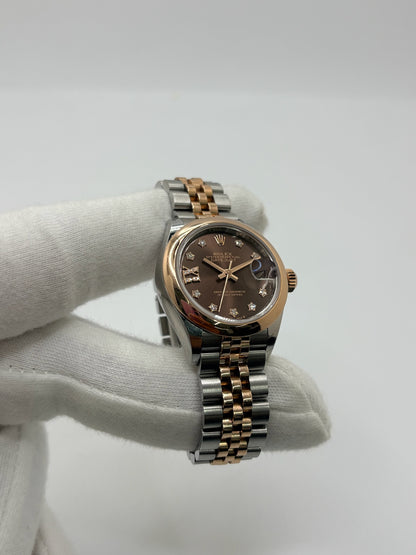 Montre Rolex Lady-Datejust référence 279161 en or et acier avec boîtier de 28 mm, fabriquée en 2023 et animée par le calibre manufacture 2236 à remontage automatique offrant 55 heures de réserve de marche. Son cadran brun avec dateur est protégé par un verre saphir et complété par un bracelet en or et acier avec boucle pliante. Cette montre Rolex d'occasion est en très bon état, révisée en interne et livrée avec son coffret et ses papiers d'origine.