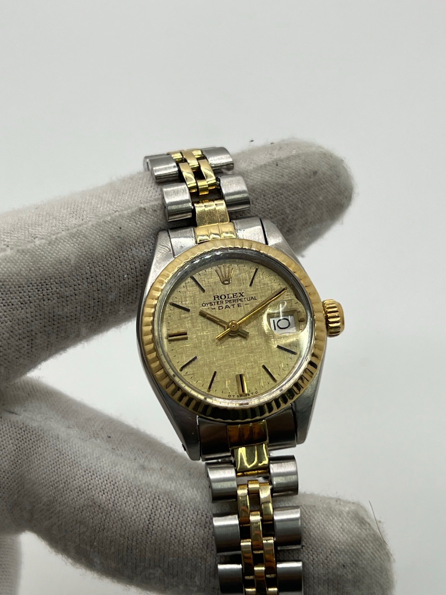 Montre Lady-Datejust référence 69173 en acier et or jaune avec cadran champagne et lunette cannelée en or jaune. Modèle féminin emblématique doté d’un mouvement automatique calibre 2135 et d’un boîtier de 26 mm avec verre saphir. Bracelet bicolore acier et or avec boucle pliante. Montre élégante et intemporelle, appréciée pour son design raffiné et sa fonction date, idéale pour les amateurs de montres classiques et d’horlogerie suisse.