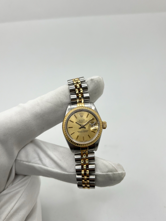 Montre Rolex Lady Datejust 26 mm réf. 69173 en acier et or jaune avec cadran champagne, lunette cannelée et bracelet Jubilé. Cette Rolex Datejust femme automatique de 1986 est équipée du calibre Rolex 2135 avec affichage de la date et verre saphir. Élégante et intemporelle, cette Rolex Lady Datejust vintage associe luxe et confort grâce à son bracelet Jubilé emblématique. Montre livrée avec boîte d’origine, certificat d’authenticité et garantie 1 an.