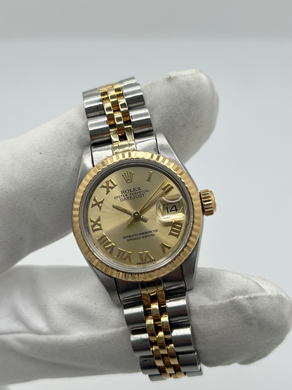 Montre Rolex Lady-Datejust 69173 de 1983 en acier et or jaune avec cadran champagne à chiffres romains, lunette cannelée et bracelet Jubilé. Cette Rolex Lady-Datejust 26 mm automatique est équipée du calibre Rolex 2135 avec affichage de la date et verre saphir. Élégante et intemporelle, cette Rolex femme vintage associe raffinement et confort grâce à son bracelet iconique acier et or. Montre livrée avec boîte d’origine, certificat d’authenticité et garantie 1 an.