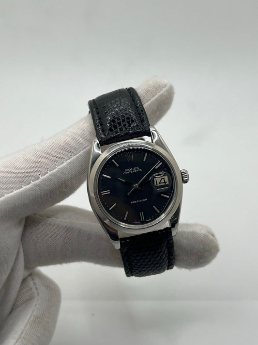 Montre Rolex Oysterdate Precision 6694, modèle vintage emblématique des années 60 en acier avec cadran noir et bracelet en cuir de lézard. Équipée d’un mouvement à remontage manuel calibre 1225, cette Rolex 6694 allie élégance intemporelle et précision horlogère, idéale pour les amateurs de montres classiques et raffinées.