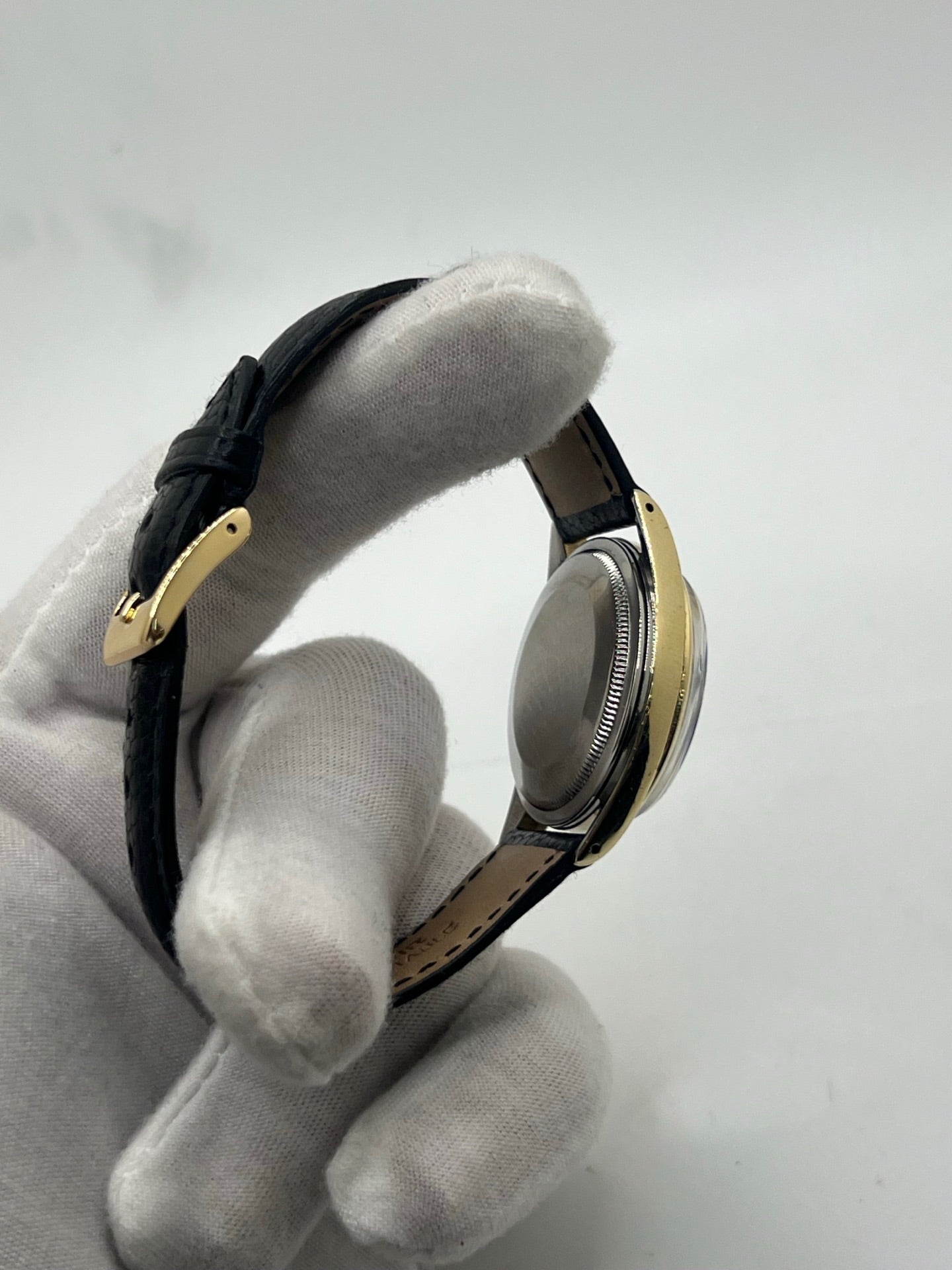 Montre Rolex Oyster Perpetual Date vintage en plaqué or, calibre automatique 1570 avec 26 pierres, cadran or et chiffres bâtons, boîtier de 34 mm, verre plexiglas. Bracelet en cuir de lézard noir avec boucle en acier. Fonction date, révision récente effectuée, coffret d’origine inclus, modèle homme/unisexe, état très bon avec légères traces d’usure.