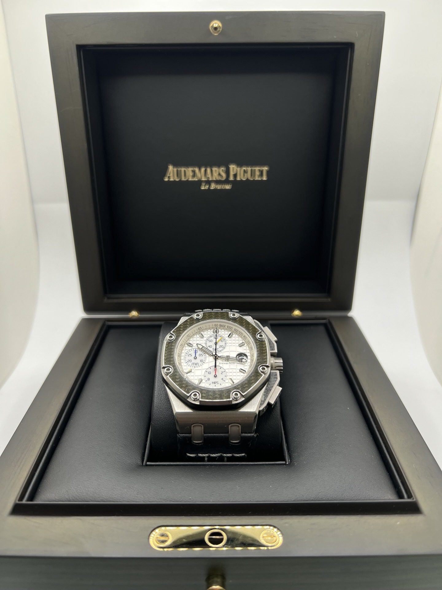 Montre Audemars Piguet Royal Oak Offshore “Juan Pablo Montoya” réf. 26030IO.OO.D001IN.01 en titane avec lunette carbone et cadran argent. Cette édition limitée à 1000 exemplaires est équipée du mouvement automatique Audemars Piguet calibre 2226/2840 avec fonction chronographe et date. Royal Oak Offshore de 44 mm inspirée de la Formule 1, avec fond transparent, bracelet cuir noir et papiers d’origine de 2004. Montre de collection rare et recherchée.