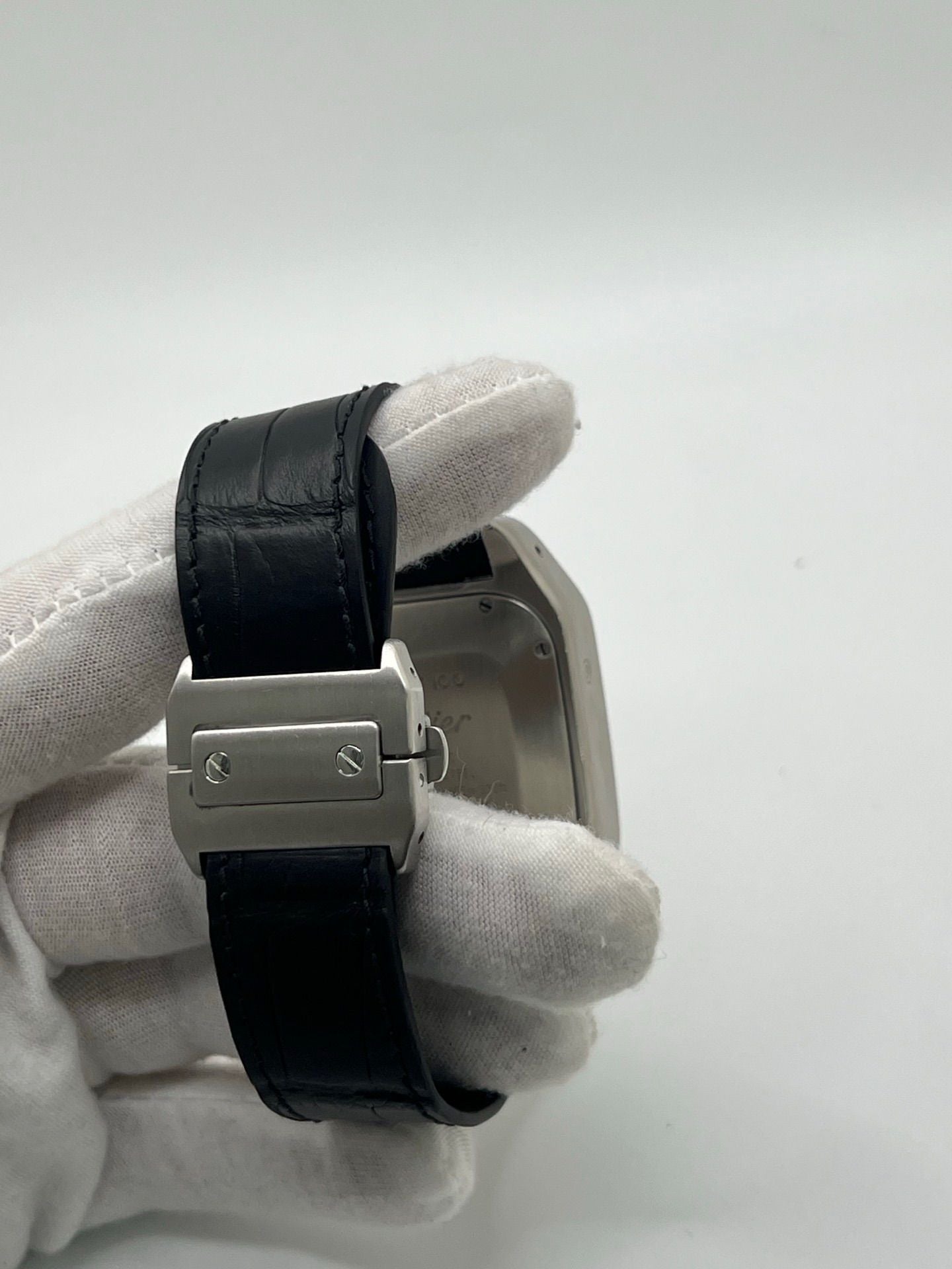 Montre Cartier Santos 100 XL Chronograph pour homme, modèle emblématique au design sport-chic. Boîtier en acier, cadran blanc à chiffres romains, bracelet en cuir noir. Mouvement automatique précis avec chronographe et date. Montre d’occasion en excellent état, révisée, livrée avec coffret d’origine.