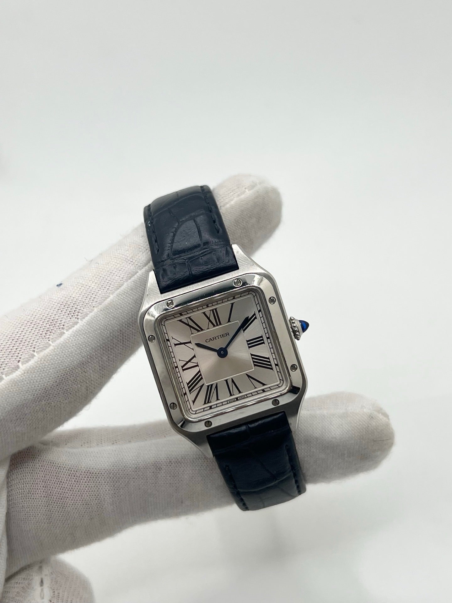 Montre élégante Santos Dumont en acier avec cadran argent et chiffres romains, équipée d’un mouvement quartz précis. Bracelet en cuir de crocodile bleu avec boucle ardillon en acier. Boîtier 38 x 27,5 mm, verre saphir et étanchéité 3 ATM. Design raffiné, idéal pour un style classique et sophistiqué. Disponible avec coffret et papiers d’origine.