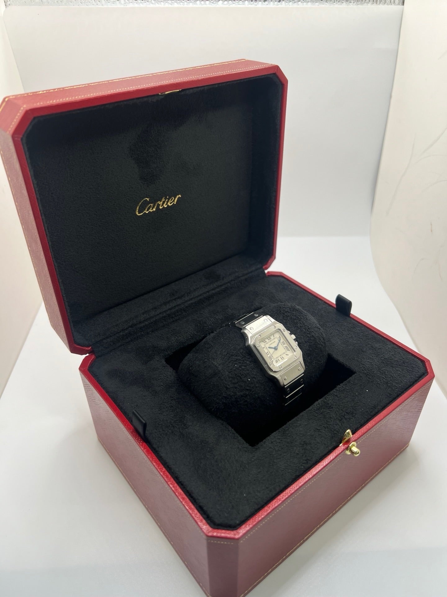 Montre Cartier Santos Lady en acier pour femme, modèle vintage à remontage automatique avec cadran blanc à chiffres romains, boîtier rectangulaire 24 x 35 mm, verre saphir et bracelet acier. Cette montre d’occasion en très bon état présente de légères traces d’usure discrètes. Livrée avec son coffret d’origine, sans papiers, cette Cartier Santos Lady allie élégance intemporelle, raffinement horloger et style iconique pour une collection de montres de luxe femme.