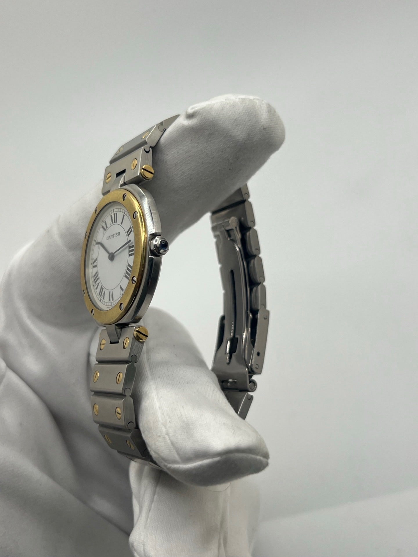 Montre Cartier Santos Ronde d'occasion en très bon état, boîtier or/acier de 33 mm avec lunette en or jaune et cadran blanc à chiffres romains. Mouvement quartz précis, verre saphir résistant aux rayures. Bracelet assorti or/acier avec boucle du même matériau. Livrée avec coffret d’origine, sans papiers. Parfaite pour collectionneurs ou amateurs de montres élégantes, disponible en stock à Paris, prix négociable