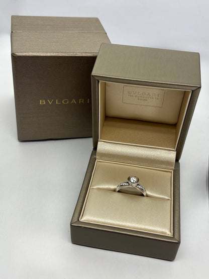 Solitaire Bulgari Incontro D'Amore en platine 950 serti d’un diamant taille brillant de 0,60 carat. Cette bague de fiançailles de luxe reflète l’élégance et le savoir-faire de la maison Bulgari grâce à son design raffiné et intemporel. Le platine met en valeur l’éclat du diamant, faisant de ce solitaire un bijou d’exception idéal pour célébrer un engagement ou enrichir une collection de joaillerie.