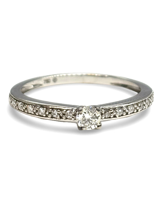 Élégante bague solitaire en or blanc, sublimée par un diamant central de 0,24 carat d’une brillance exceptionnelle. Un bijou raffiné qui incarne la pureté et l’éclat intemporel du diamant, parfait pour une demande en mariage ou pour symboliser un amour éternel avec finesse et sophistication.
