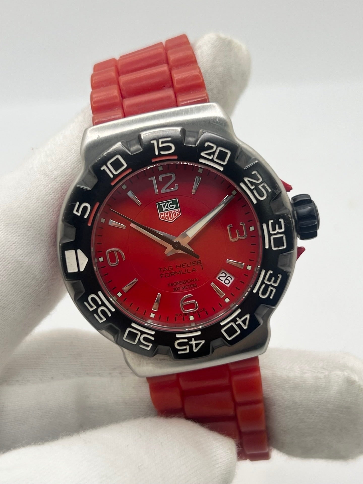 Montre TAG Heuer Formula 1 Quartz réf. WAC1113-0 en acier avec mouvement à quartz, cadran rouge à chiffres arabes et lunette en céramique. Son boîtier de 40 mm est associé à un bracelet en caoutchouc rouge avec boucle ardillon en acier, offrant un style sportif et un excellent confort. Cette TAG Heuer Formula 1 d'occasion est en très bon état, révisée en interne et disponible immédiatement. Elle dispose également d'un affichage de la date.