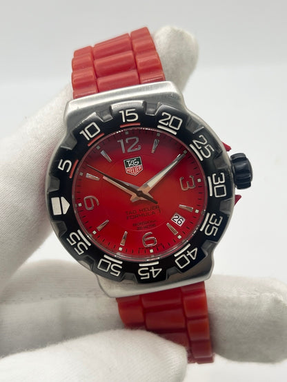 Montre TAG Heuer Formula 1 Quartz réf. WAC1113-0 en acier avec mouvement à quartz, cadran rouge à chiffres arabes et lunette en céramique. Son boîtier de 40 mm est associé à un bracelet en caoutchouc rouge avec boucle ardillon en acier, offrant un style sportif et un excellent confort. Cette TAG Heuer Formula 1 d'occasion est en très bon état, révisée en interne et disponible immédiatement. Elle dispose également d'un affichage de la date.