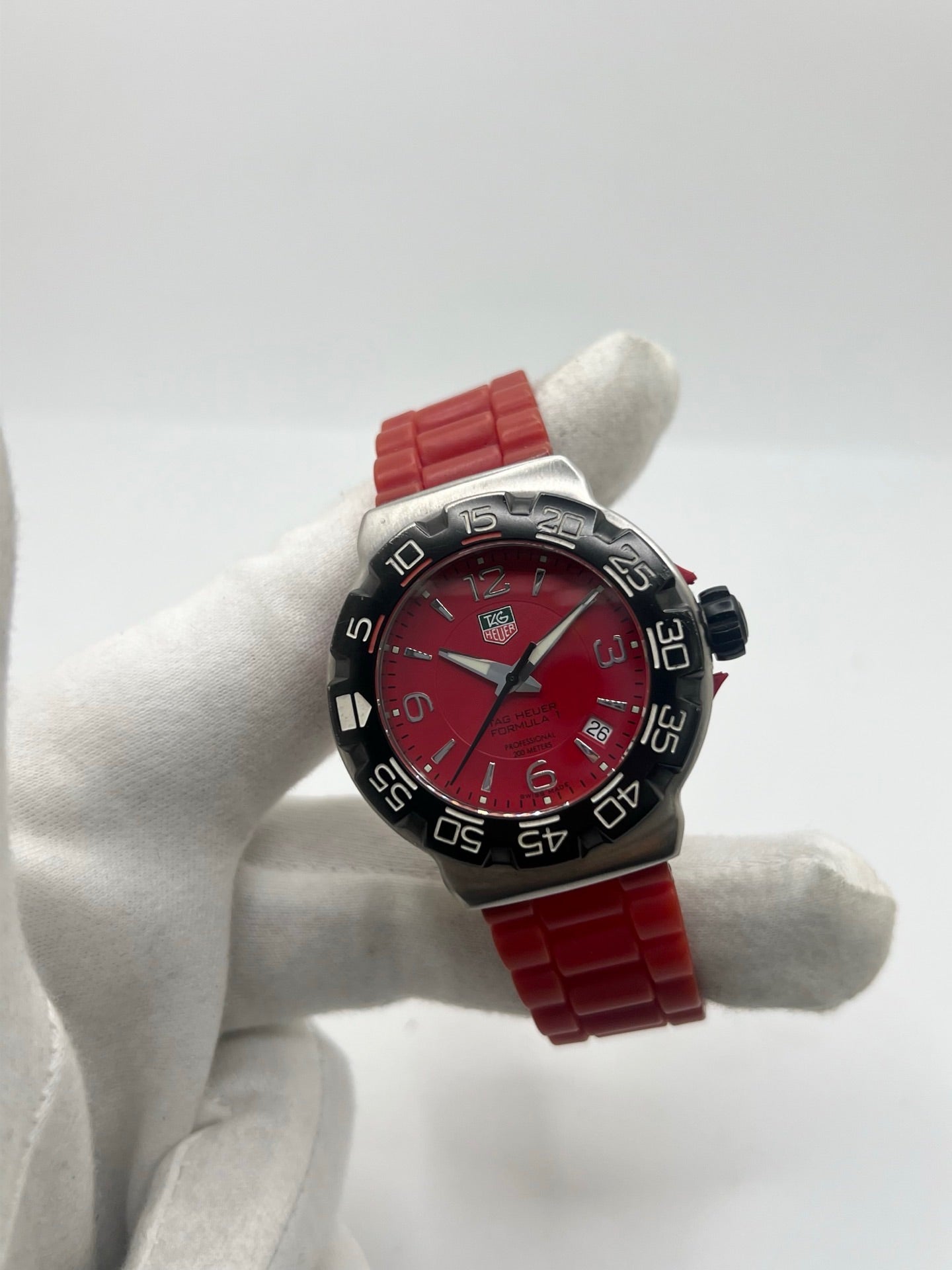 Montre TAG Heuer Formula 1 Quartz réf. WAC1113-0 en acier avec mouvement à quartz, cadran rouge à chiffres arabes et lunette en céramique. Son boîtier de 40 mm est associé à un bracelet en caoutchouc rouge avec boucle ardillon en acier, offrant un style sportif et un excellent confort. Cette TAG Heuer Formula 1 d'occasion est en très bon état, révisée en interne et disponible immédiatement. Elle dispose également d'un affichage de la date.