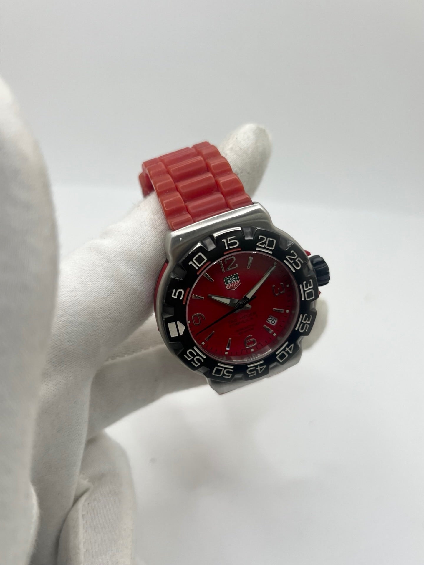 Montre TAG Heuer Formula 1 Quartz réf. WAC1113-0 en acier avec mouvement à quartz, cadran rouge à chiffres arabes et lunette en céramique. Son boîtier de 40 mm est associé à un bracelet en caoutchouc rouge avec boucle ardillon en acier, offrant un style sportif et un excellent confort. Cette TAG Heuer Formula 1 d'occasion est en très bon état, révisée en interne et disponible immédiatement. Elle dispose également d'un affichage de la date.