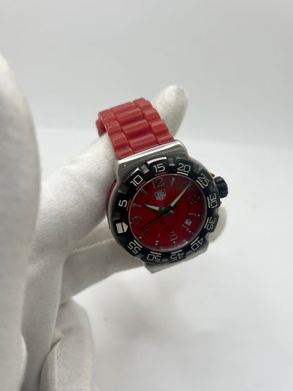 Montre TAG Heuer Formula 1 Quartz réf. WAC1113-0 en acier avec mouvement à quartz, cadran rouge à chiffres arabes et lunette en céramique. Son boîtier de 40 mm est associé à un bracelet en caoutchouc rouge avec boucle ardillon en acier, offrant un style sportif et un excellent confort. Cette TAG Heuer Formula 1 d'occasion est en très bon état, révisée en interne et disponible immédiatement. Elle dispose également d'un affichage de la date.