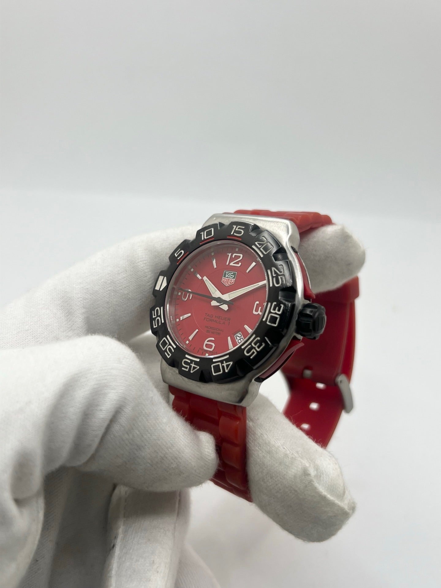 Montre TAG Heuer Formula 1 Quartz réf. WAC1113-0 en acier avec mouvement à quartz, cadran rouge à chiffres arabes et lunette en céramique. Son boîtier de 40 mm est associé à un bracelet en caoutchouc rouge avec boucle ardillon en acier, offrant un style sportif et un excellent confort. Cette TAG Heuer Formula 1 d'occasion est en très bon état, révisée en interne et disponible immédiatement. Elle dispose également d'un affichage de la date.