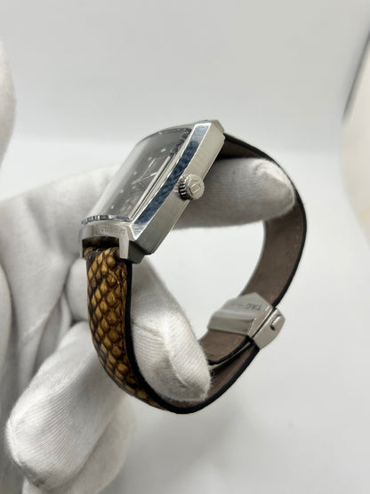 Montre TAG Heuer Monaco Calibre 6 WW2115 pour homme, équipée d’un mouvement automatique offrant une réserve de marche de 42 heures et du calibre 6 doté de 27 pierres. Son boîtier en acier de 37 mm accueille un cadran brun au style élégant et distinctif. Cette TAG Heuer Monaco est montée sur un bracelet en cuir de serpent avec boucle déployante en acier. Dotée d’un affichage de la date, elle allie design emblématique et savoir-faire horloger. Vendue avec son coffret d’origine, en très bon état.