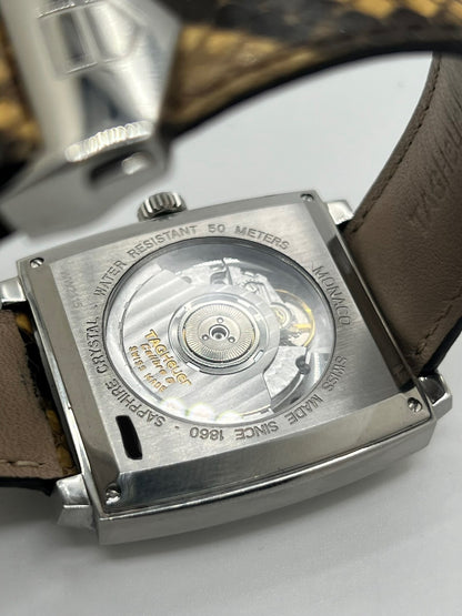 Montre TAG Heuer Monaco Calibre 6 WW2115 pour homme, équipée d’un mouvement automatique offrant une réserve de marche de 42 heures et du calibre 6 doté de 27 pierres. Son boîtier en acier de 37 mm accueille un cadran brun au style élégant et distinctif. Cette TAG Heuer Monaco est montée sur un bracelet en cuir de serpent avec boucle déployante en acier. Dotée d’un affichage de la date, elle allie design emblématique et savoir-faire horloger. Vendue avec son coffret d’origine, en très bon état.
