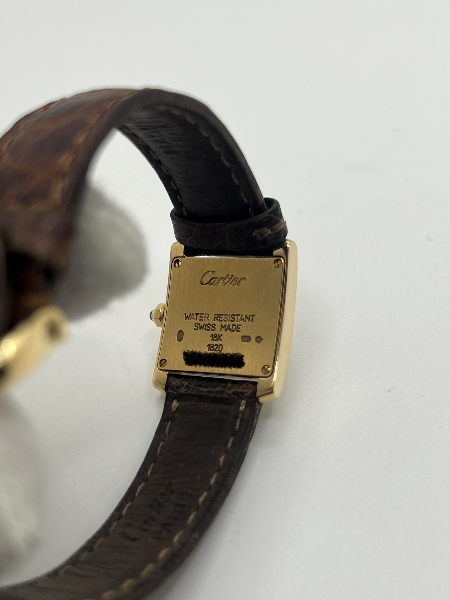 Montre Cartier Tank Française référence 1820 en or jaune 18K, petit modèle pour femme, boîtier rectangulaire emblématique aux lignes droites et élégantes, cadran blanc avec chiffres romains noirs, minuterie chemin de fer et aiguilles bleuies en forme de glaive. Bracelet intégré en acier avec boucle déployante. Mouvement quartz précis. Montre de luxe intemporelle, raffinée et iconique, idéale pour un porté quotidien ou une tenue habillée.