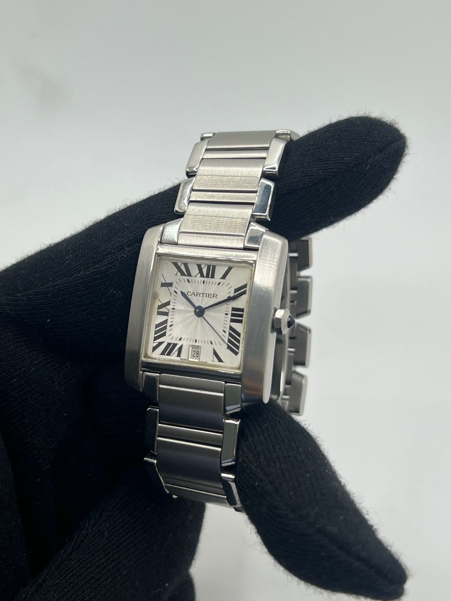 Montre Cartier Tank Française pour homme/unisexe en acier avec mouvement automatique Cartier 120. Boîtier 28x32 mm, cadran blanc à chiffres romains, verre saphir, étanchéité 3 ATM. Bracelet acier avec boucle double plis. Fonction date. État d’occasion bon, livré avec coffret d’origine, idéal pour collection ou usage quotidien élégant.