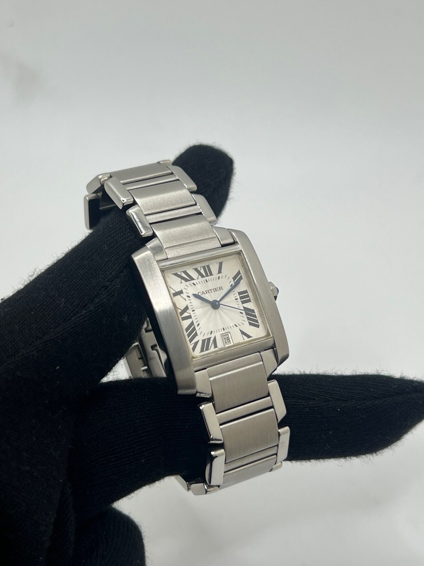Montre Cartier Tank Française pour homme/unisexe en acier avec mouvement automatique Cartier 120. Boîtier 28x32 mm, cadran blanc à chiffres romains, verre saphir, étanchéité 3 ATM. Bracelet acier avec boucle double plis. Fonction date. État d’occasion bon, livré avec coffret d’origine, idéal pour collection ou usage quotidien élégant.
