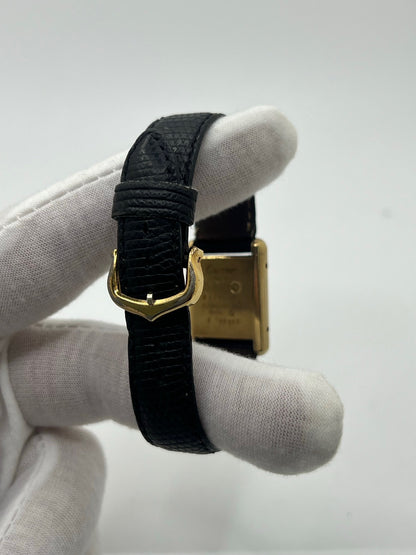 Montre Cartier Tank Must Vermeil référence 5057001 pour femme, boîtier en argent 20 x 28 mm, cadran noir sans chiffres et bracelet en cuir de lézard noir. Modèle à mouvement quartz, en bon état avec traces d’usure légères. Montre élégante au style intemporel, idéale pour un look sophistiqué et raffiné. Parfaite pour les amateurs de pièces vintage.