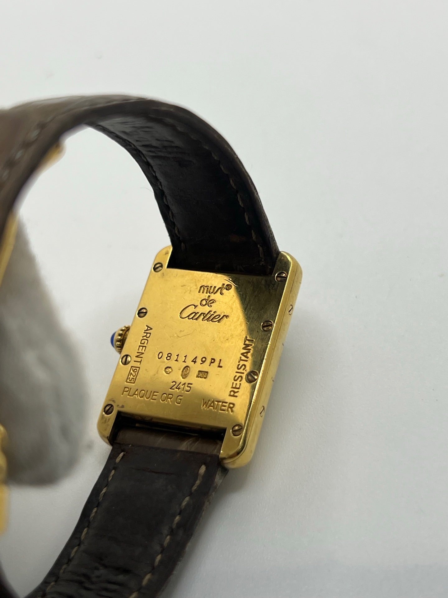 Montre Cartier Tank Vermeil 2415 pour femme, équipée d’un mouvement quartz et d’un boîtier en argent de 22 x 29 mm. Ce modèle d’occasion en bon état présente des traces d’usure visibles, un cadran blanc à chiffres arabes, un verre minéral et un bracelet en cuir brun avec boucle ardillon en argent. Élégante et classique, la Cartier Tank Vermeil 2415 séduit par son design intemporel, idéale pour les passionnées de montres de luxe.