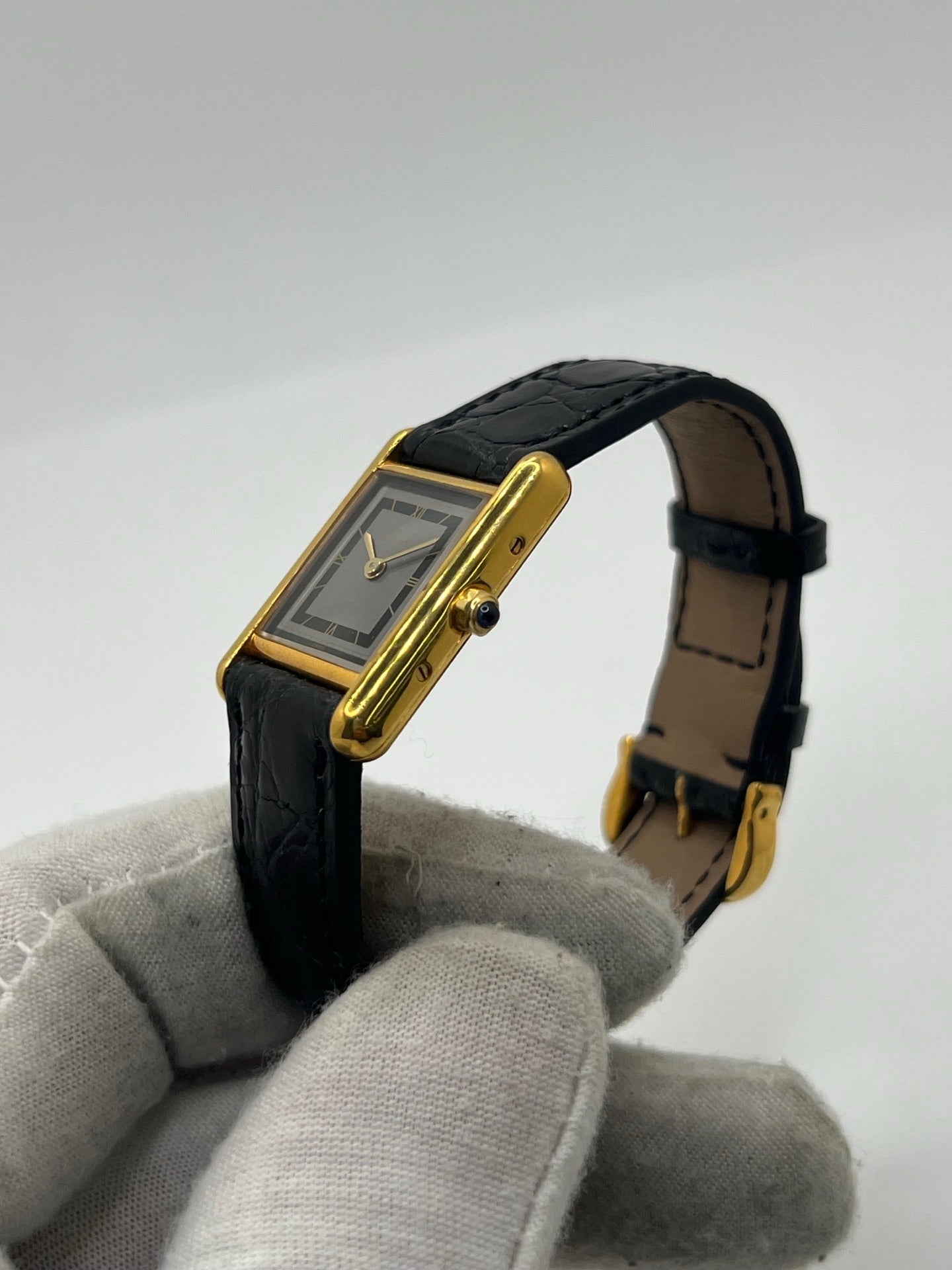 Montre Cartier Tank Vermeil 3 66001 pour femme, équipée d’un mouvement quartz et d’un boîtier en argent de 20 x 27 mm. Ce modèle d’occasion en très bon état présente un cadran or à chiffres romains, un verre minéral et un bracelet en cuir de crocodile noir avec boucle en acier. Élégante et intemporelle, la Cartier Tank Vermeil 3 66001 séduit par son design classique, idéale pour les passionnées de montres de luxe raffinées.