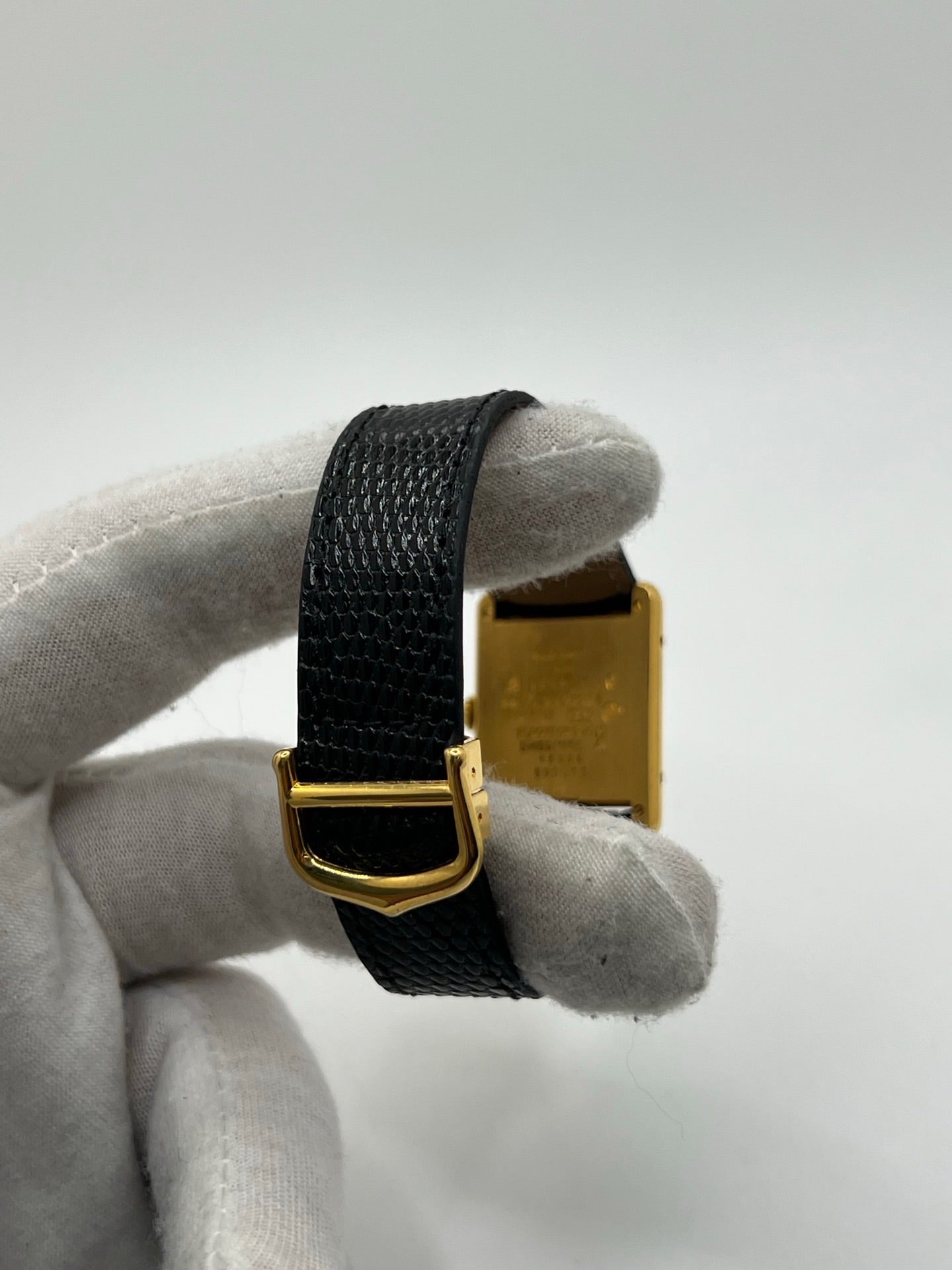 Montre Cartier Tank Vermeil référence 590005 vintage de 1989, avec boîtier rectangulaire en argent aux proportions classiques 23 x 30 mm, cadran argenté élégant avec chiffres arabes noirs et aiguilles bleuies, verre saphir et mouvement quartz. Montée sur un bracelet en cuir de lézard noir avec boucle ardillon en acier. Modèle iconique au design intemporel, livré avec son coffret et ses papiers d’origine, en très bon état.