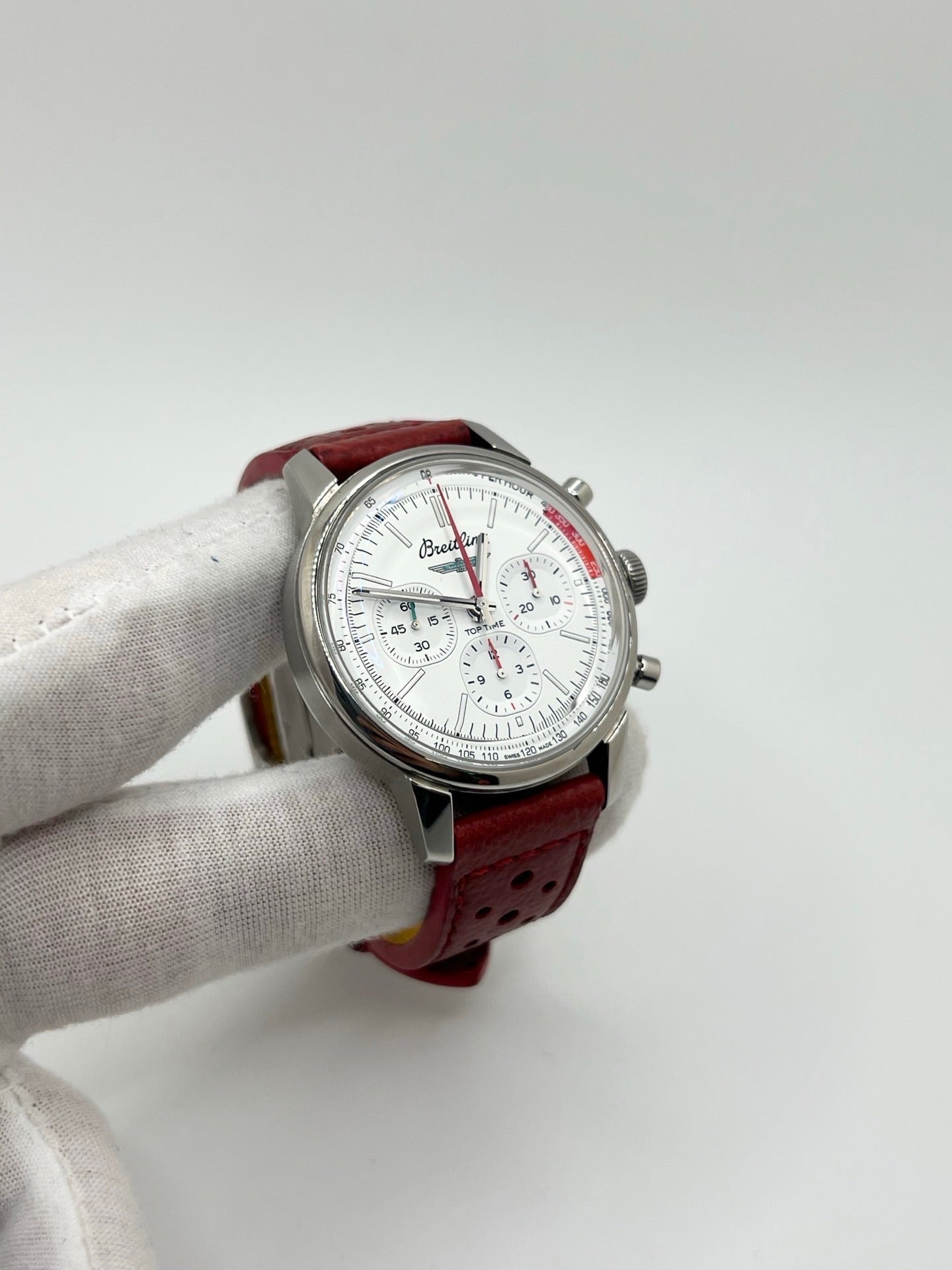 Montre chronographe automatique pour homme au design inspiré des années 60, dotée d’un boîtier en acier de 41 mm, d’un cadran blanc épuré sans chiffres et de compteurs contrastés. Mouvement automatique calibre 01 avec réserve de marche de 70 heures, verre saphir et étanchéité 10 ATM. Bracelet en cuir rouge avec boucle en acier, style sportif et vintage, montre mécanique suisse en très bon état avec coffret et papiers d’origine.