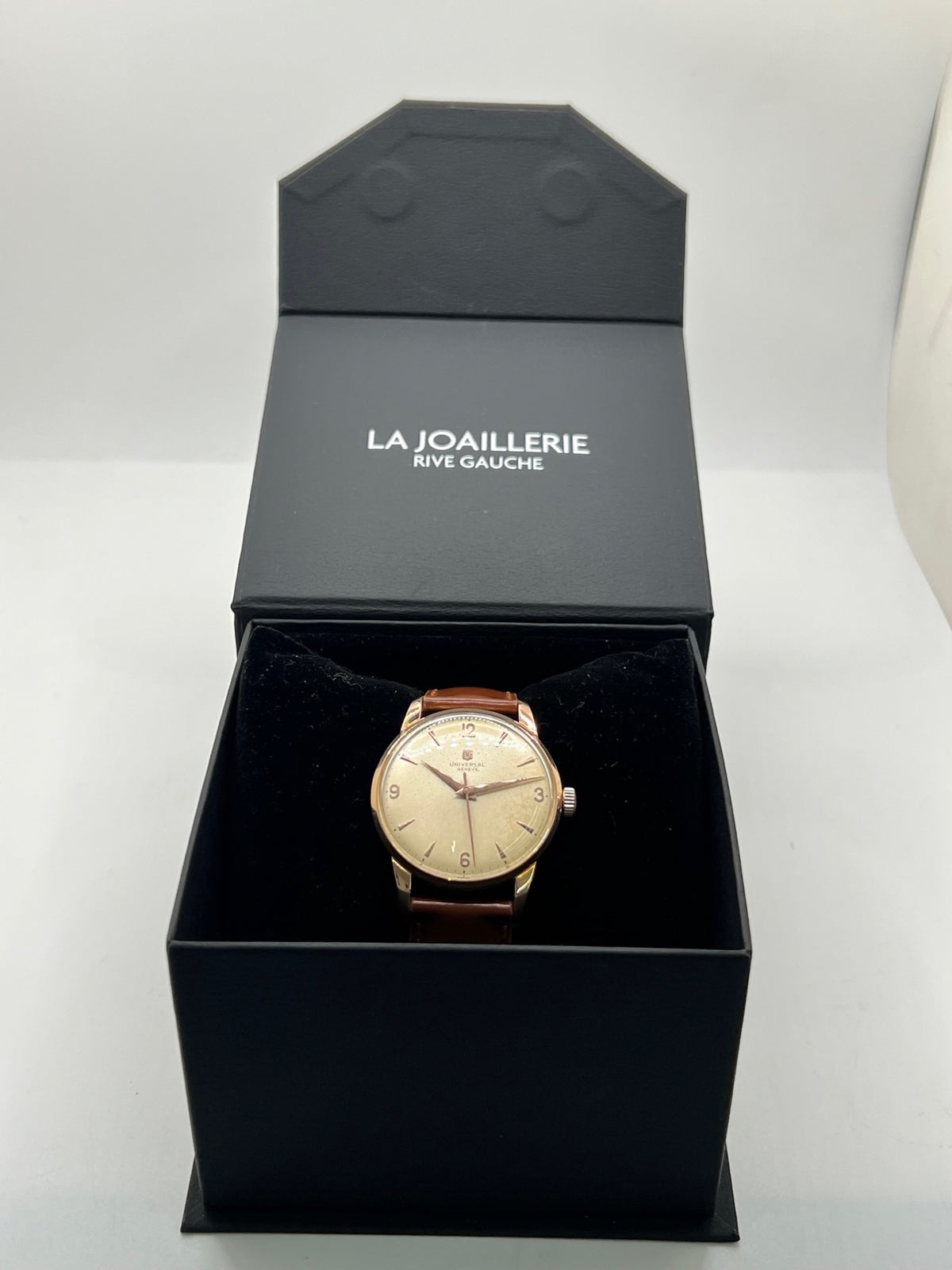 Montre Universal Genève 412501/1 vintage en très bon état, datant approximativement de 1950, avec un mouvement à remontage manuel. Son boîtier de 34,5 mm plaqué or est associé à un cadran blanc à chiffres arabes et un verre Plexiglas. Cette montre Universal Genève possède un bracelet en cuir brun avec boucle ardillon en acier. Un modèle homme ou unisexe au style classique et élégant, idéal pour les amateurs d’horlogerie vintage.