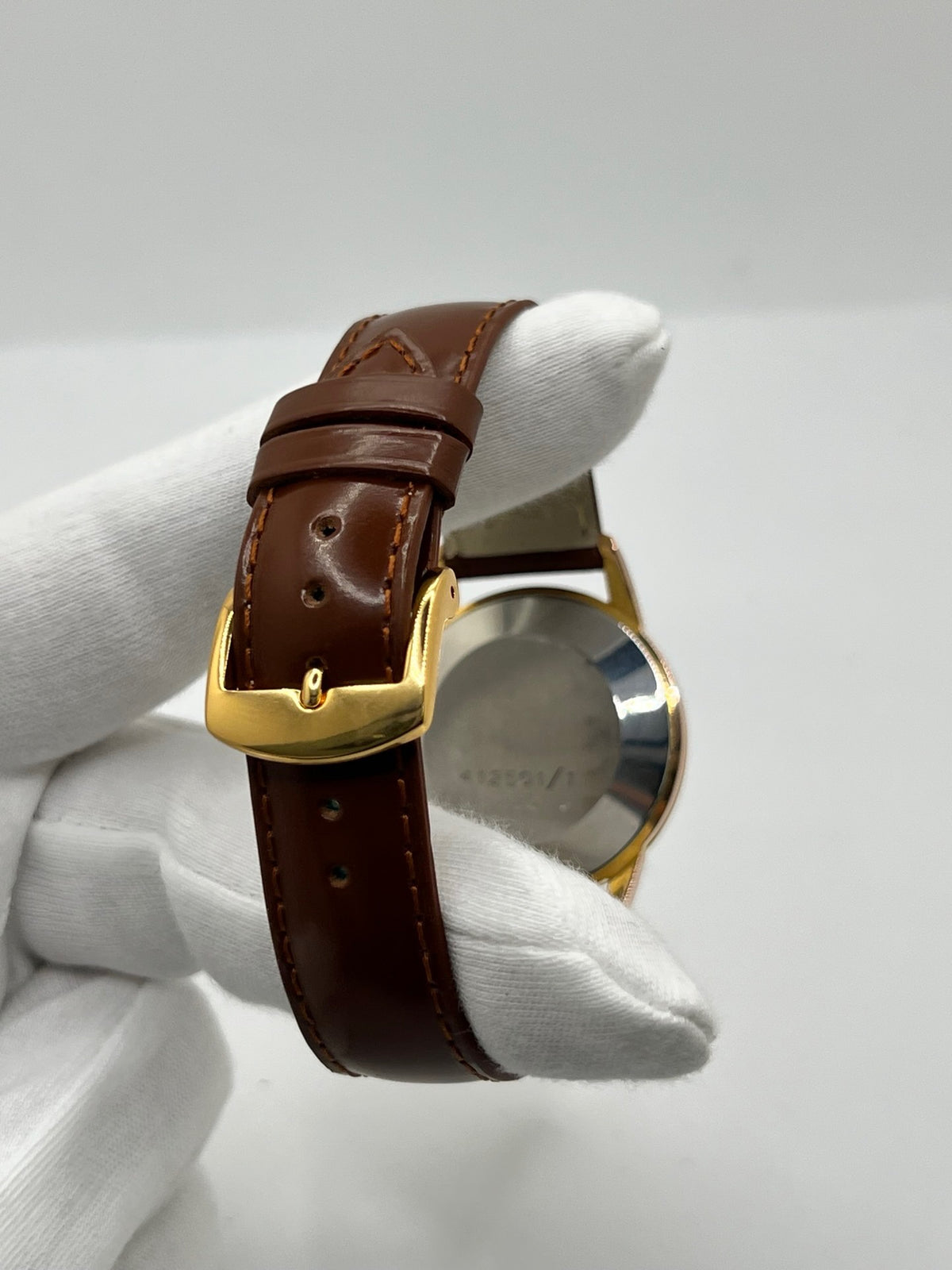 Montre Universal Genève 412501/1 vintage en très bon état, datant approximativement de 1950, avec un mouvement à remontage manuel. Son boîtier de 34,5 mm plaqué or est associé à un cadran blanc à chiffres arabes et un verre Plexiglas. Cette montre Universal Genève possède un bracelet en cuir brun avec boucle ardillon en acier. Un modèle homme ou unisexe au style classique et élégant, idéal pour les amateurs d’horlogerie vintage.