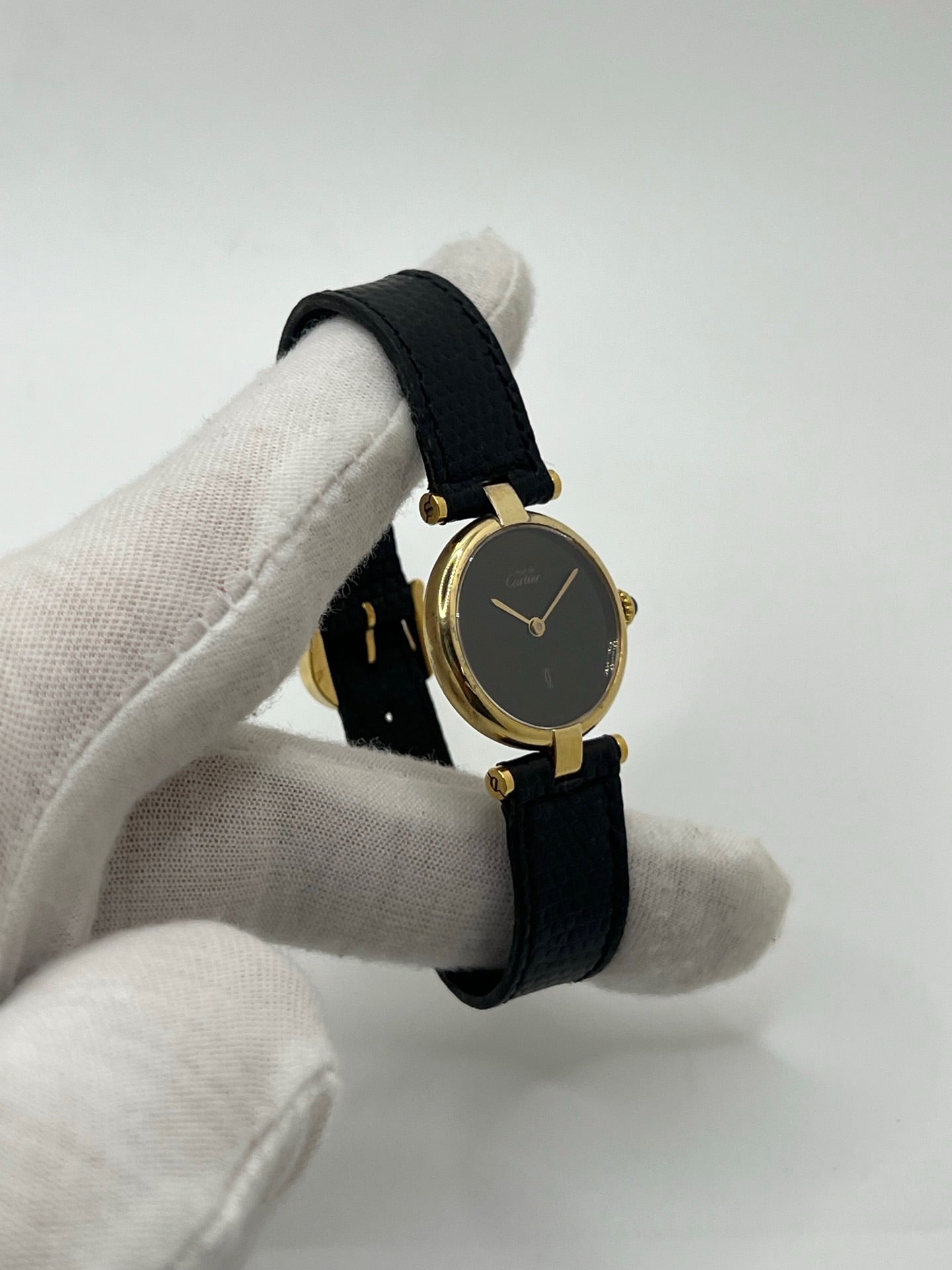 Montre Cartier Must de Cartier Vendome pour femme, boîtier argent de 24 mm avec cadran noir sans chiffres, mouvement quartz précis, verre saphir résistant aux rayures, bracelet cuir noir avec boucle ardillon en acier. État d’occasion très bon, livrée avec coffret d’origine. Élégante et intemporelle, idéale pour collection ou usage quotidien.