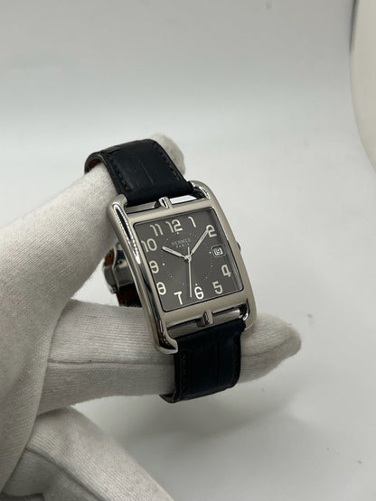 Montre Hermès Cape Cod XL pour homme ou unisexe, modèle emblématique au boîtier en acier de 33 mm. Mouvement quartz, cadran gris à chiffres arabes, bracelet cuir noir avec boucle ardillon. Élégance intemporelle signée Hermès, livrée avec coffret d’origine. Parfait état d’occasion avec légères traces d’usure. Disponible à Paris, prix négociable. Idéal collectionneur ou amateur de montres de luxe.
