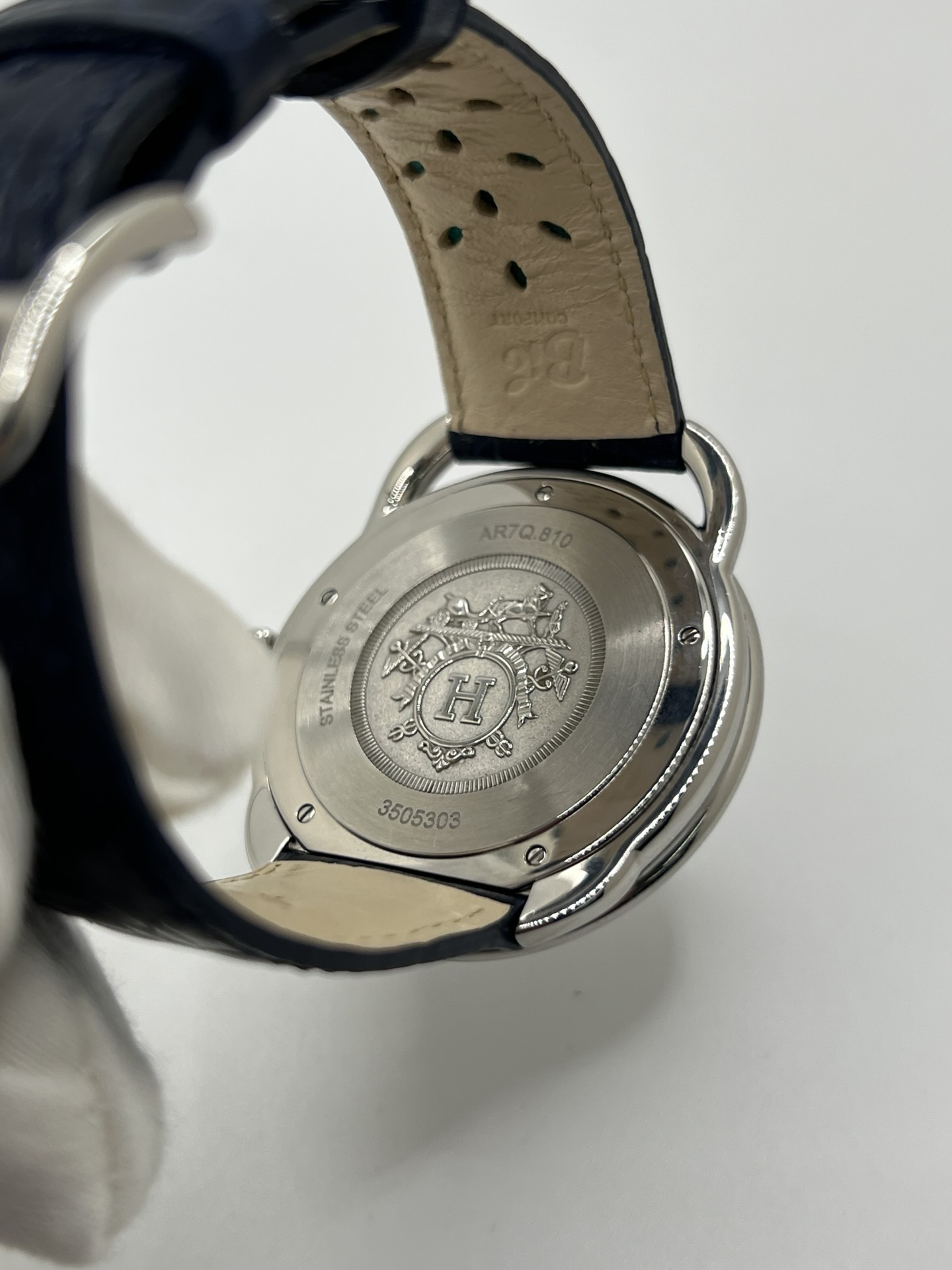 Montre Hermès Arceau grand modèle AR7Q.810 en acier avec cadran blanc épuré, chiffres arabes inclinés signature de la collection Arceau, mouvement quartz précis et bracelet en cuir élégant. Design intemporel et raffiné, idéal pour une tenue chic au quotidien ou une occasion spéciale, alliant savoir-faire horloger et esthétique minimaliste.
