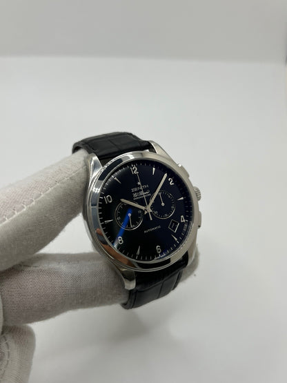 Montre Zenith El Primero automatique en acier de 2007, modèle homme ou unisexe avec boîtier de 44 mm et cadran noir à chiffres arabes. Ce chronographe d’occasion en très bon état dispose d’un verre saphir, d’une fonction date et d’un bracelet en cuir noir avec boucle ardillon. Élégante et précise, la Zenith El Primero séduit par son design iconique et sa performance horlogère, idéale pour les passionnés de montres de luxe et de chronographes haut de gamme.