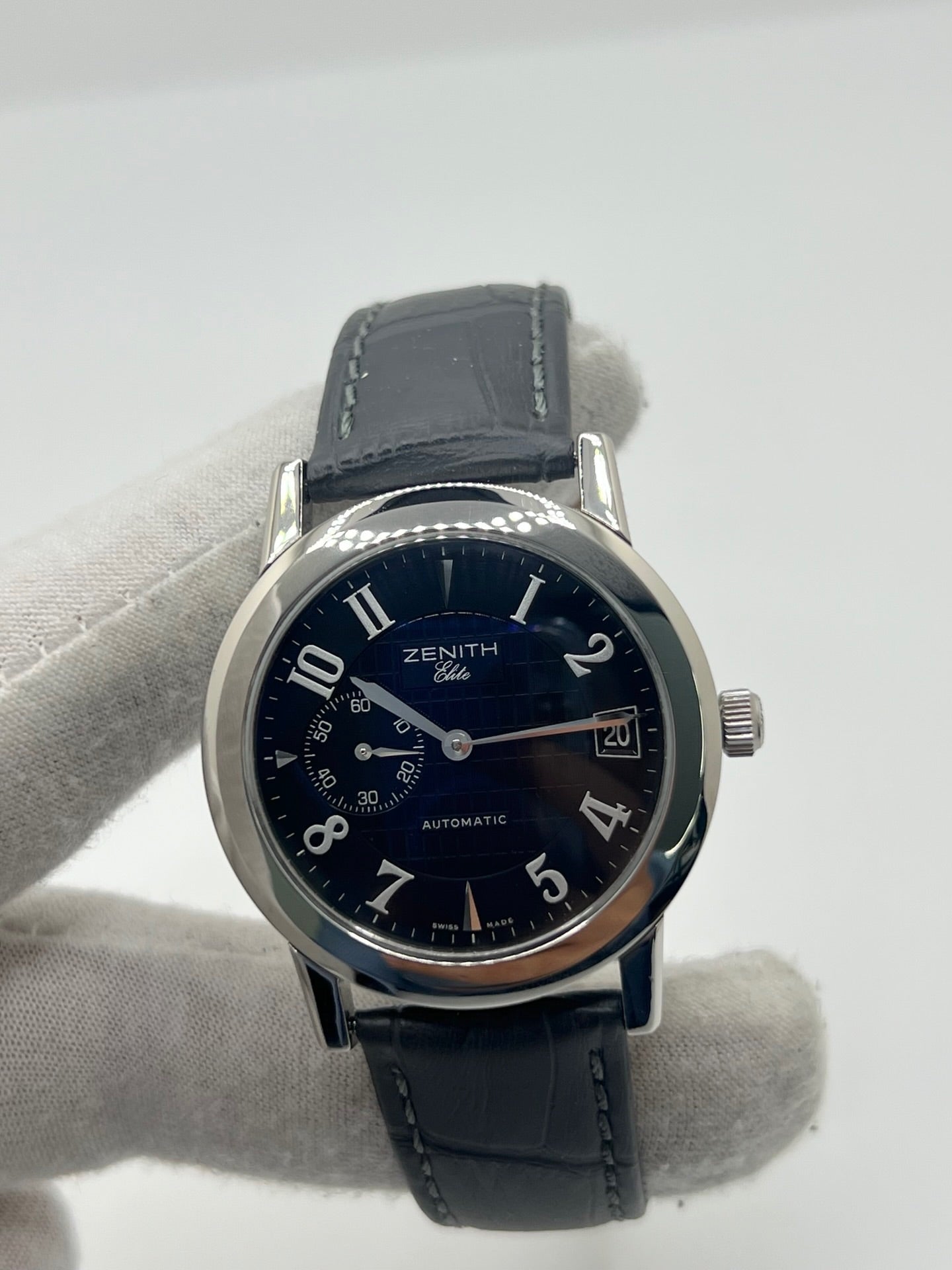 Montre Zenith Port Royal automatique en acier, modèle homme ou unisexe de 2007, équipée d’un boîtier de 37 mm et d’un élégant cadran noir à chiffres arabes. Cette montre d’occasion en très bon état dispose d’un verre saphir, d’une fonction date et d’une petite seconde. Son bracelet en cuir noir avec boucle ardillon souligne son style raffiné. Une montre Zenith Port Royal de luxe au design intemporel, idéale pour les passionnés d’horlogerie et les amateurs de pièces élégantes.