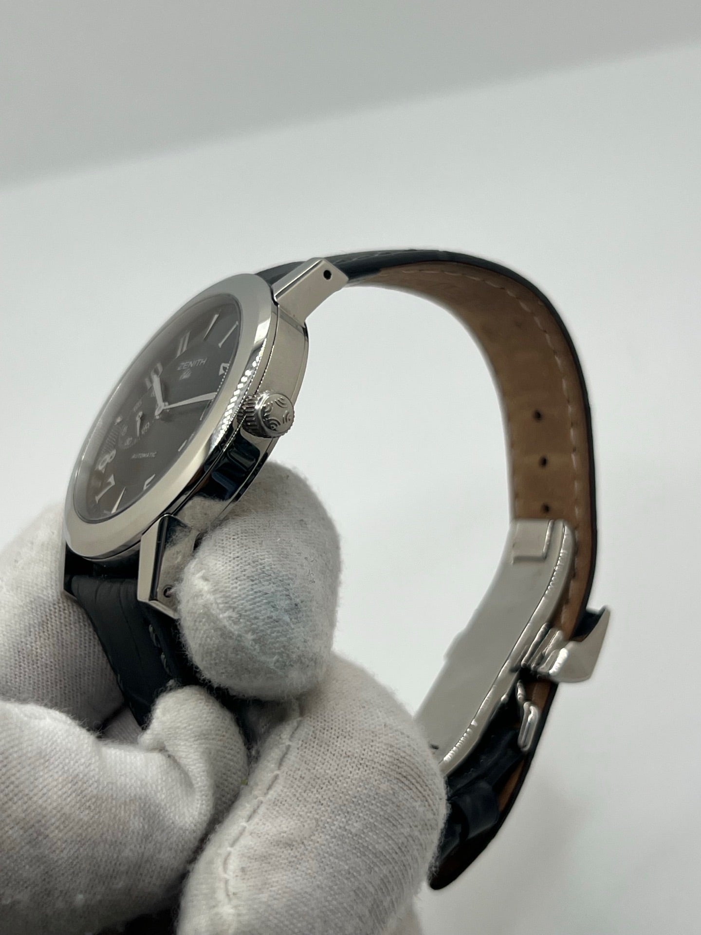 Montre Zenith Port Royal automatique en acier, modèle homme ou unisexe de 2007, équipée d’un boîtier de 37 mm et d’un élégant cadran noir à chiffres arabes. Cette montre d’occasion en très bon état dispose d’un verre saphir, d’une fonction date et d’une petite seconde. Son bracelet en cuir noir avec boucle ardillon souligne son style raffiné. Une montre Zenith Port Royal de luxe au design intemporel, idéale pour les passionnés d’horlogerie et les amateurs de pièces élégantes.