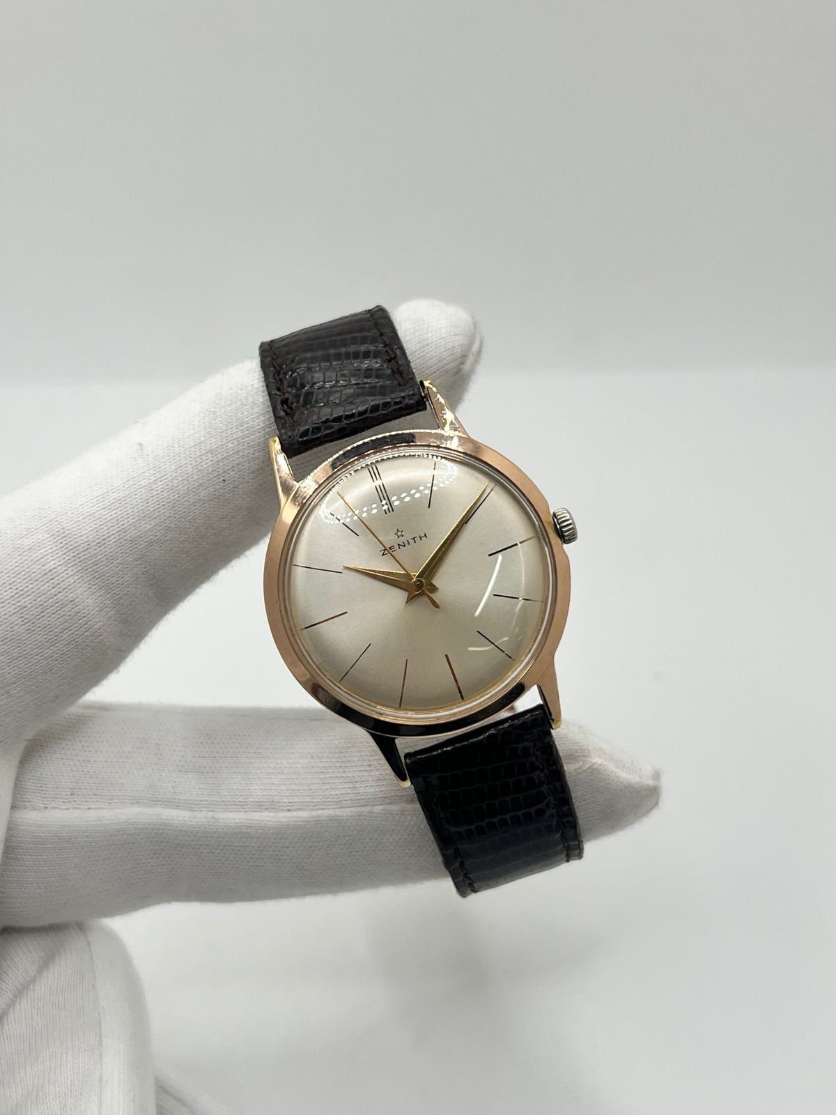 Montre Zenith Stellina vintage à remontage manuel, dotée d’un boîtier plaqué or et d’un élégant cadran champagne. Cette montre Zenith se distingue par son style classique et intemporel, emblématique de l’horlogerie traditionnelle. Elle est équipée d’un bracelet brun en cuir de lézard, complété par une boucle ardillon en acier. Avec son esthétique raffinée et son allure rétro, la Zenith Stellina séduit les amateurs de montres anciennes et de pièces horlogères au charme authentique.